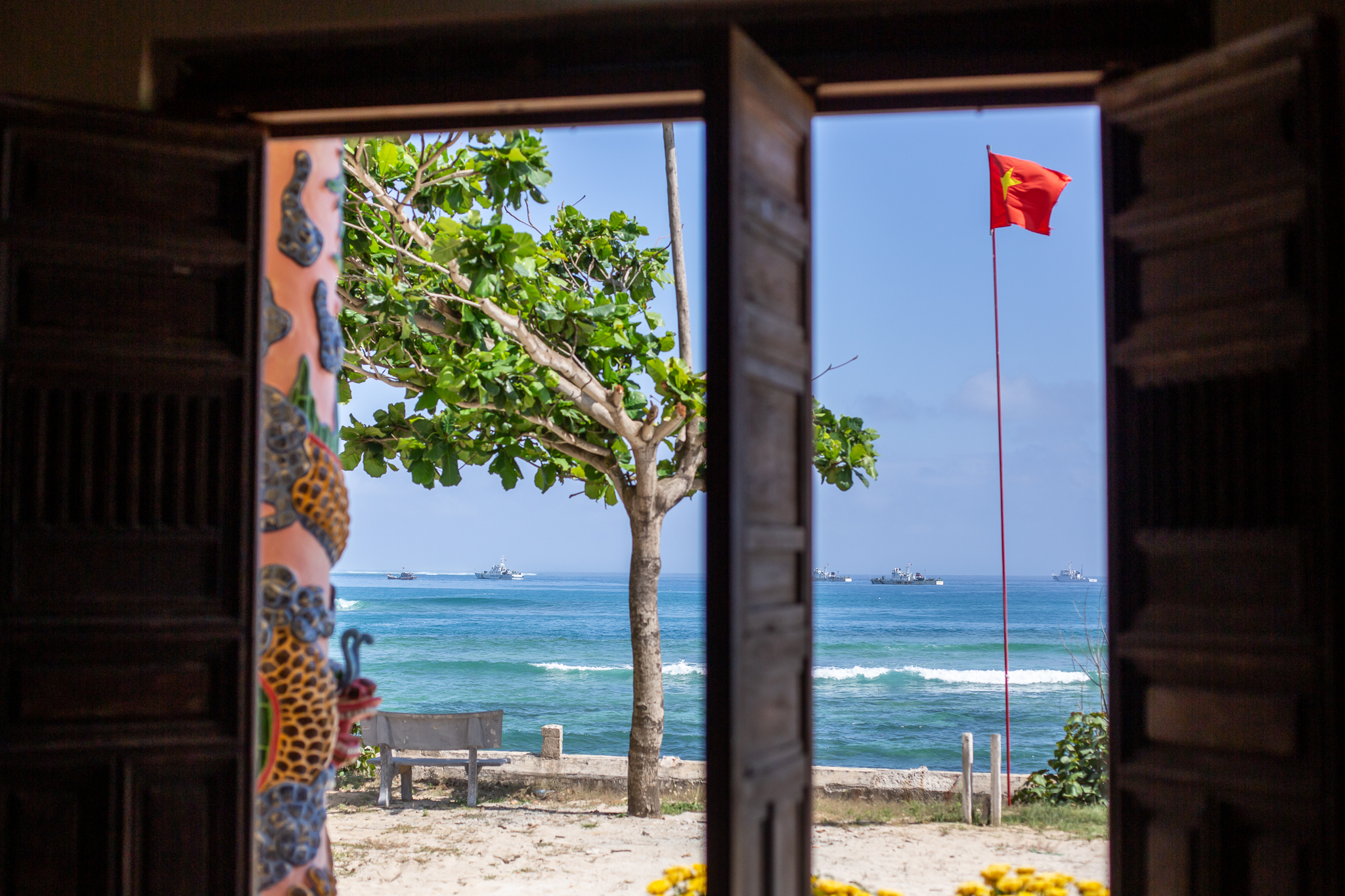 A photo from the steps of one of Ly Son’s whale temples with numerous Vietnamese coast guard vessels standing guard in the view,