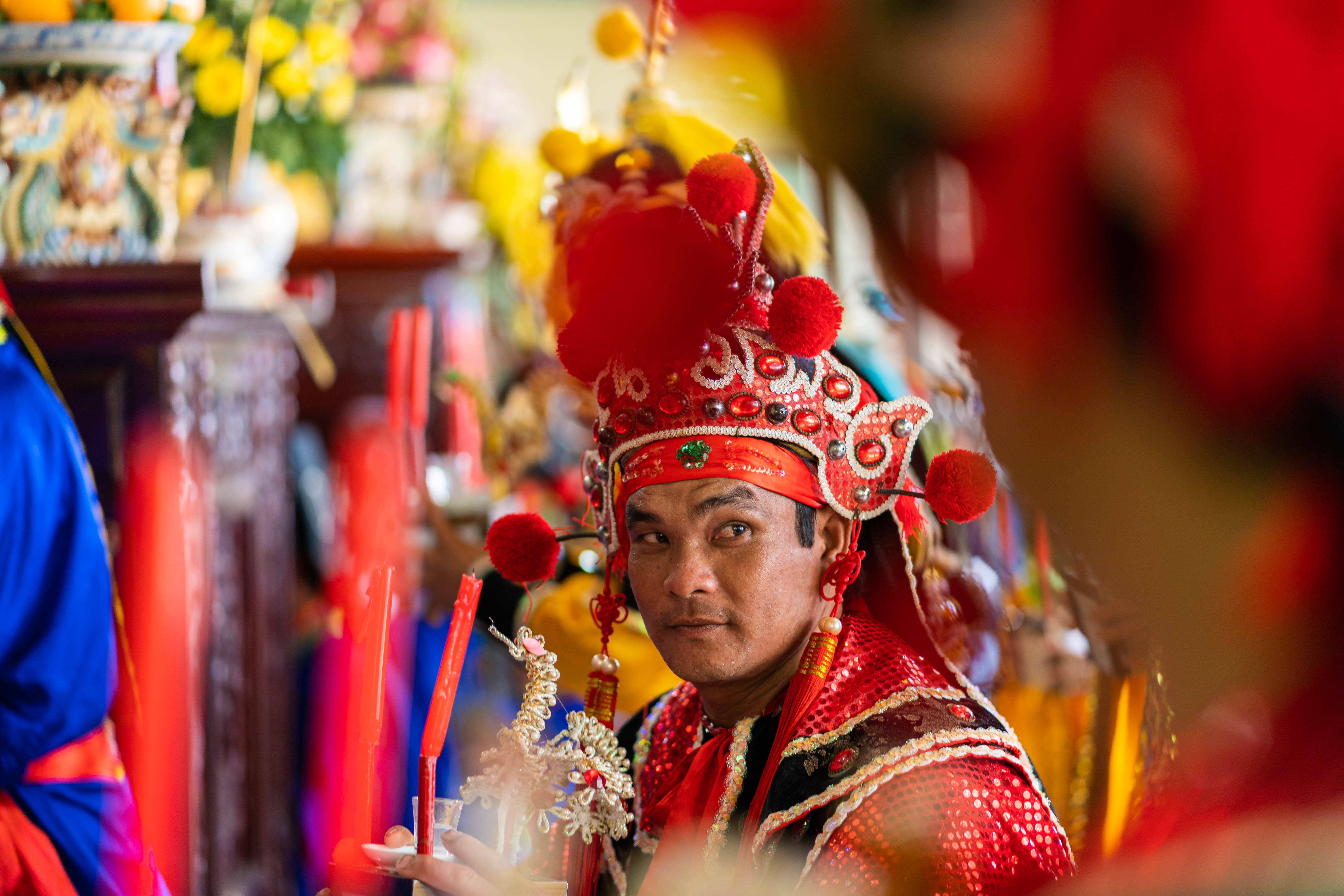 A photo of whale worshippers in elaborate dress carrying candles and flowers as part of a co-ordinated ritual during Phuoc Hai’s whale worship festival.
