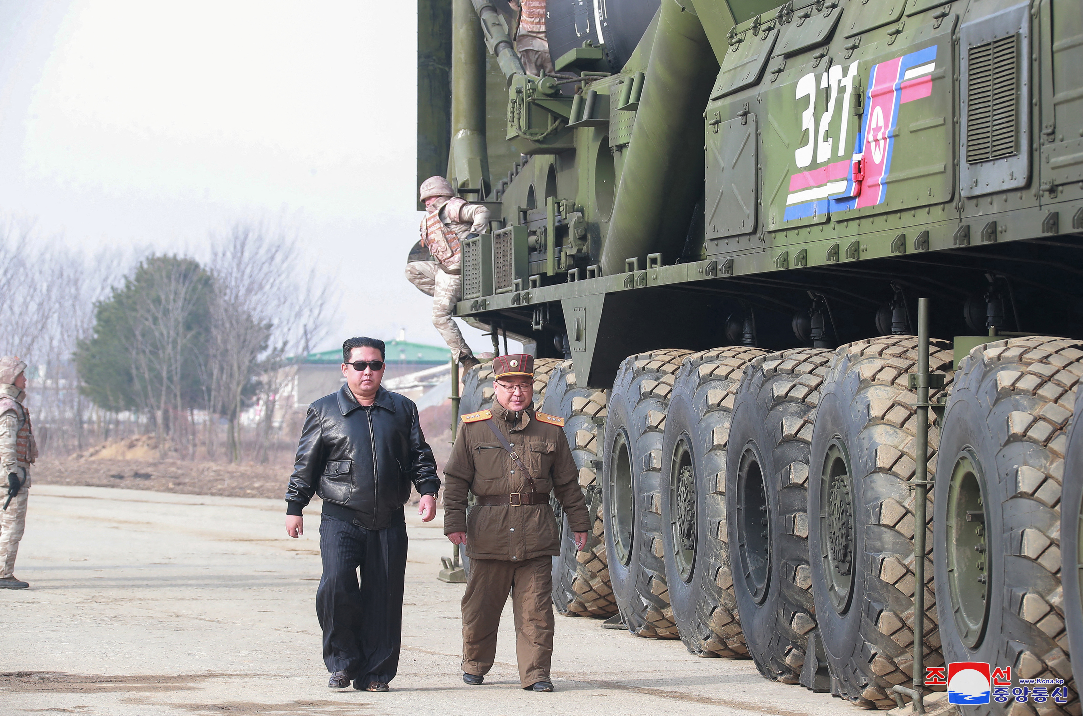 Kim Jong Un walking past a Hawsong-17 missile on a tarmac.