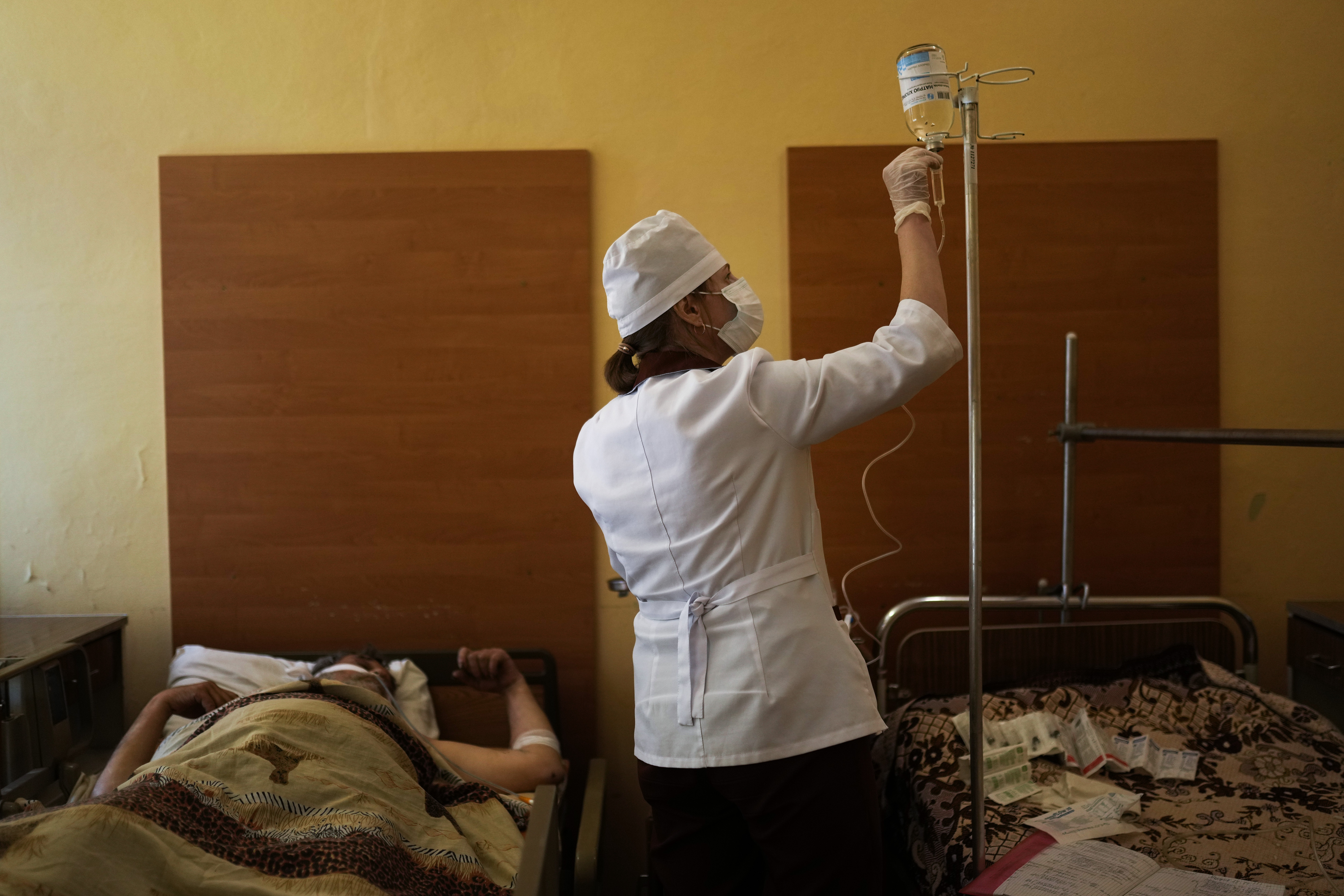 A nurse tends to a patient after he underwent surgery for injuries to his leg and abdomen caused by a mine explosion in Severodonetsk, at Kostyantynivka hospital in eastern Ukraine, Monday, May 23, 2022