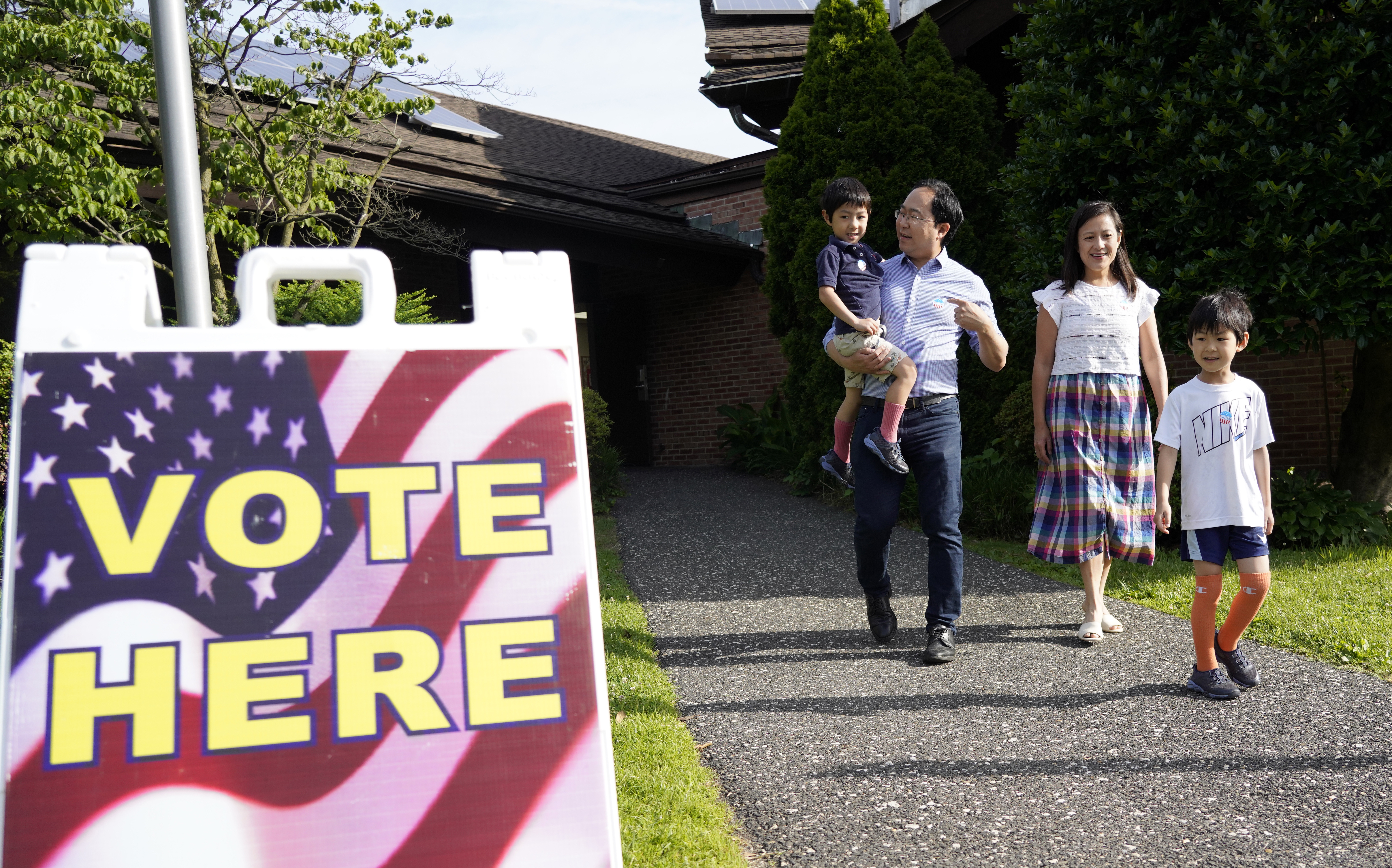 Family walks near an elections poster