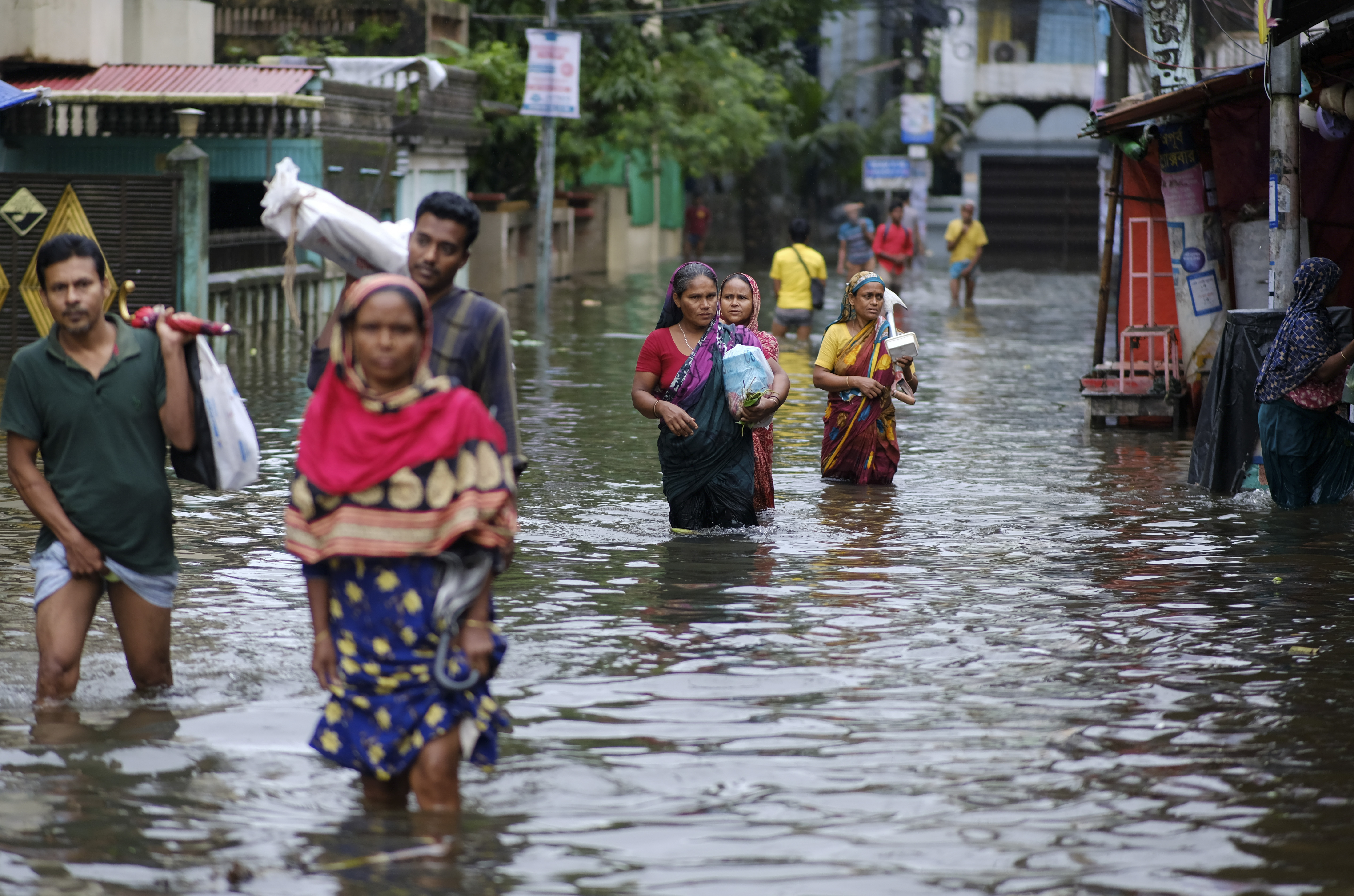 People wade through flood waters in Sylhet