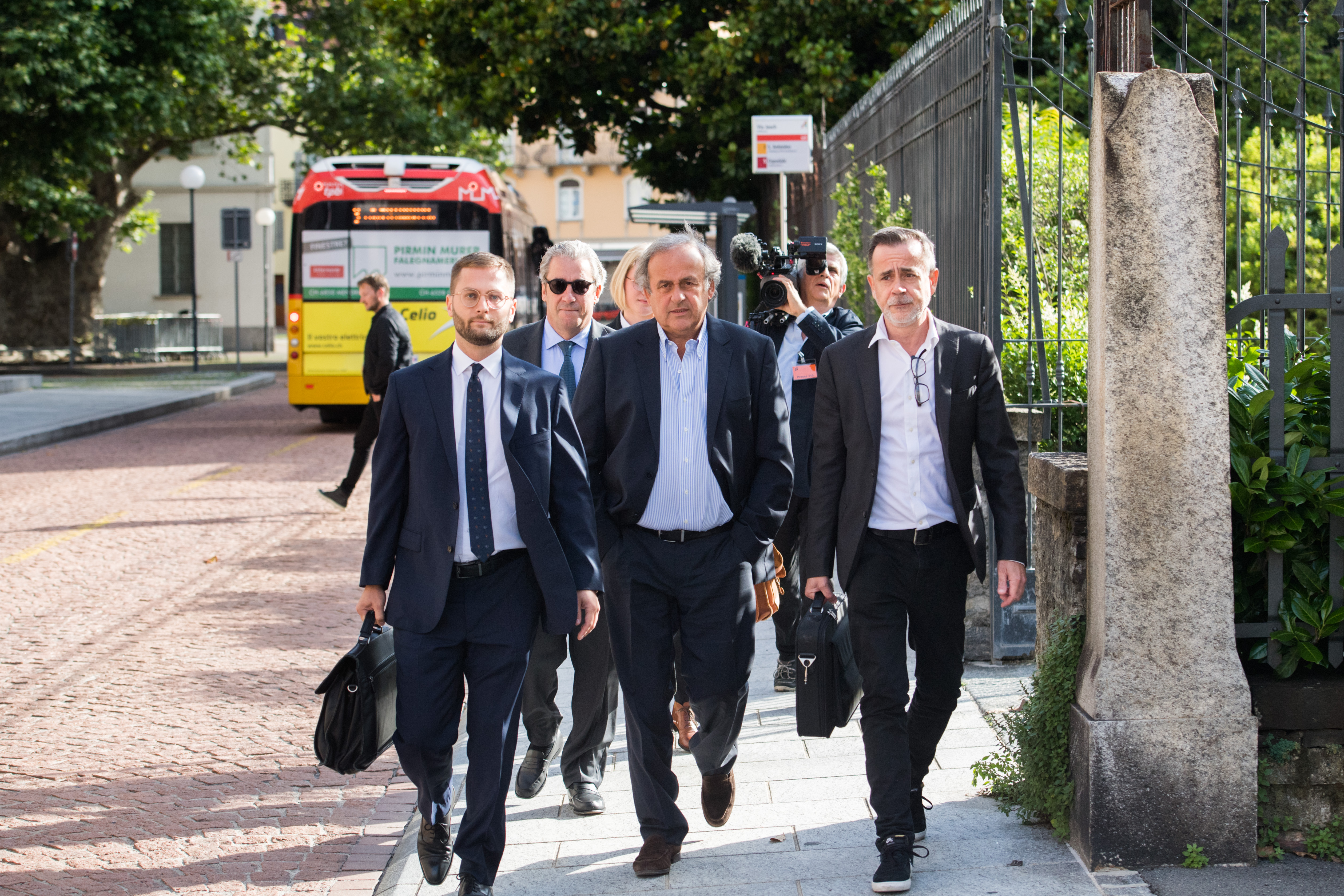The former president of the the European Football Association (Uefa), Michel Platini (C), and his lawyers arrive to the process at the Swiss Federal Criminal Court