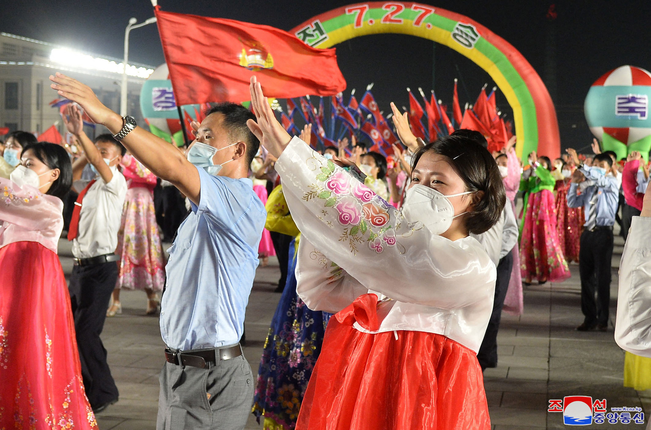 A woman in traditional Korean hanbok in red and white — and a mask — during North Korea's 'Victory Day' celebrations.