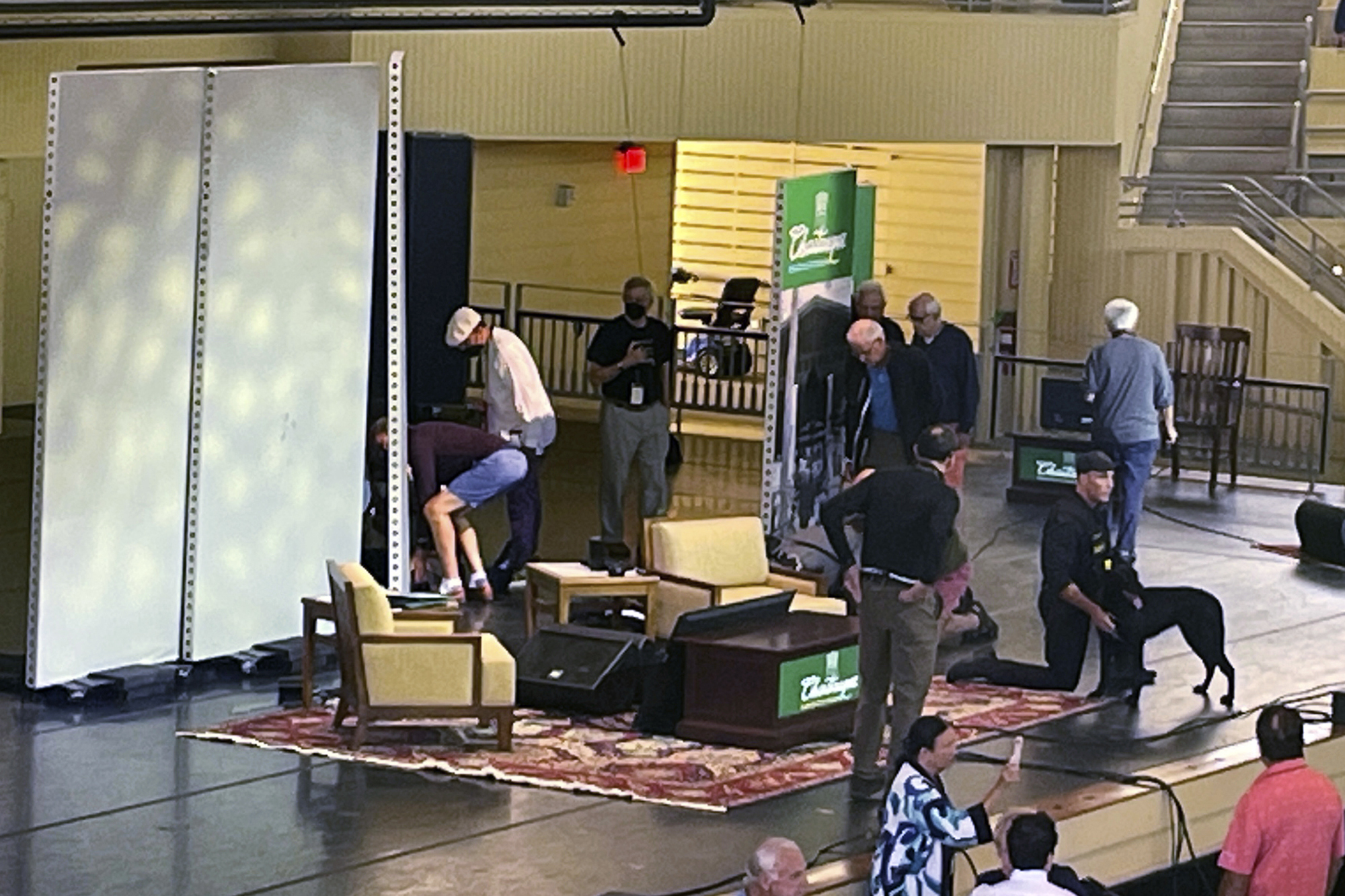 Author Salman Rushdie, behind screen left, is tended to after he was attacked in New York state.
