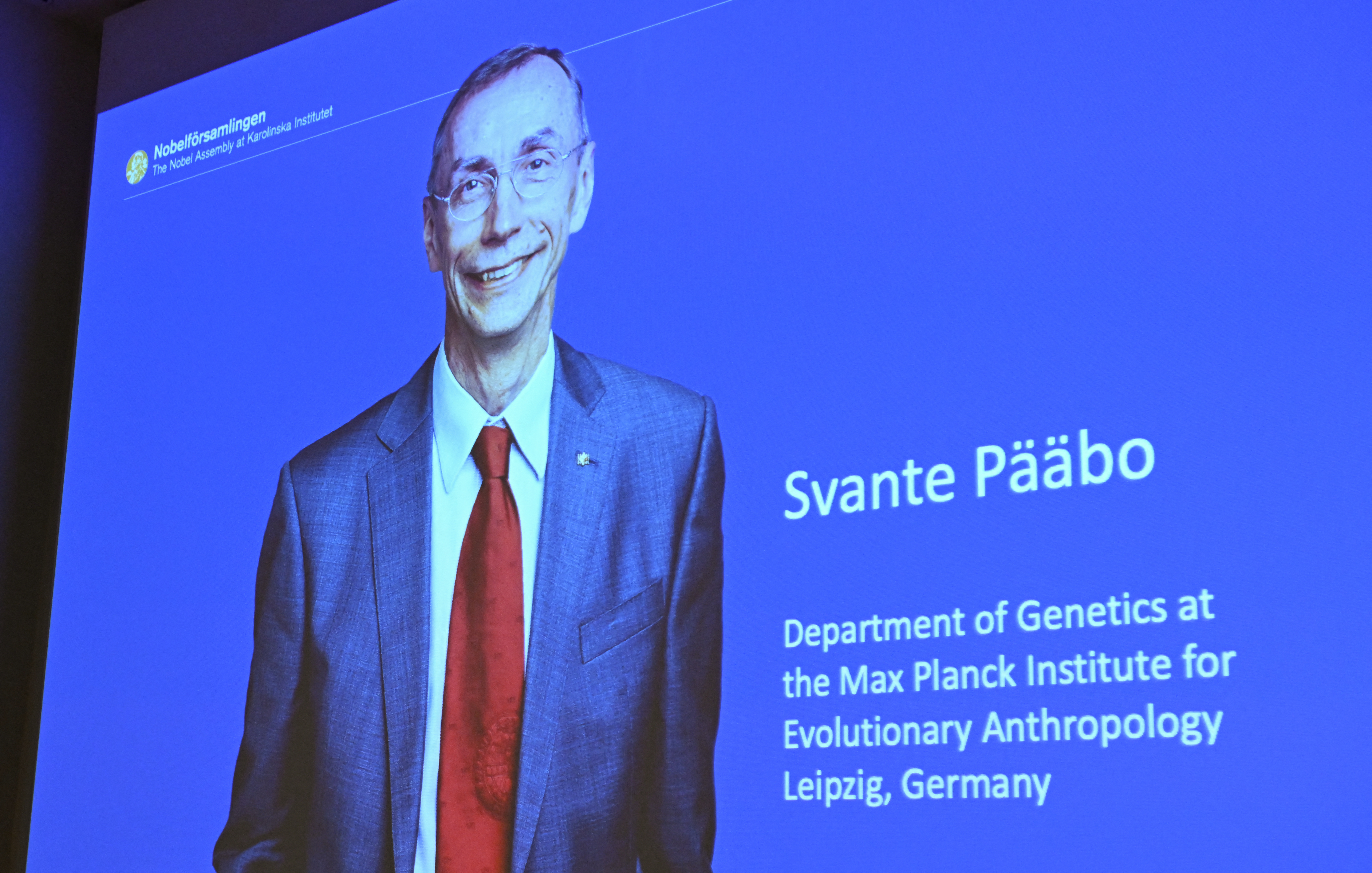 A screen shows the winner of the 2022 Nobel Prize in Physiology or Medicine Sweden's Svante Paabo