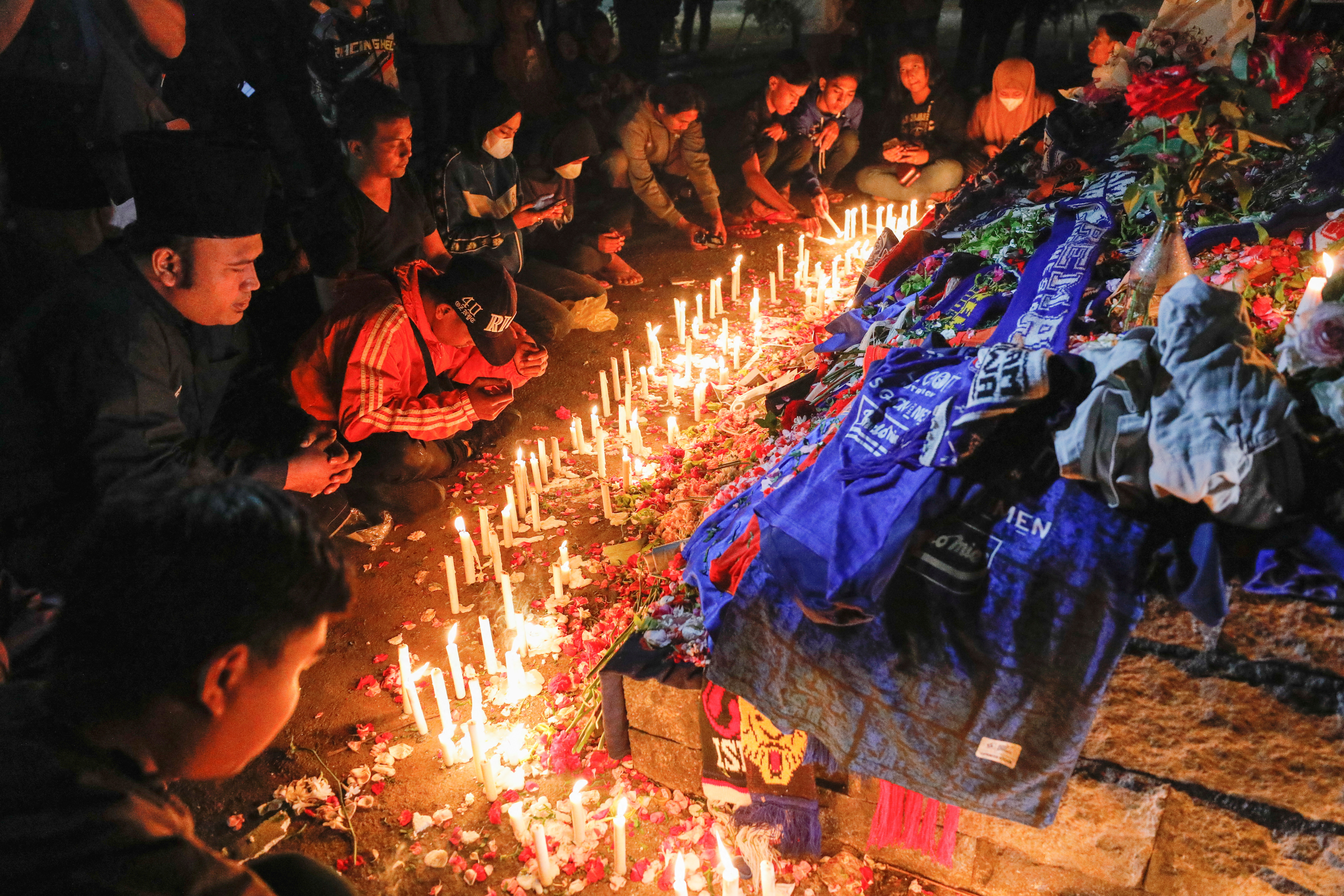 Supporters attend a vigil to pay respects to the victims of the riot and stampede following a soccer match between Arema vs Persebaya, outside the Kanjuruhan Stadium in Malang, East Java province, Indonesia, October 3, 2022.