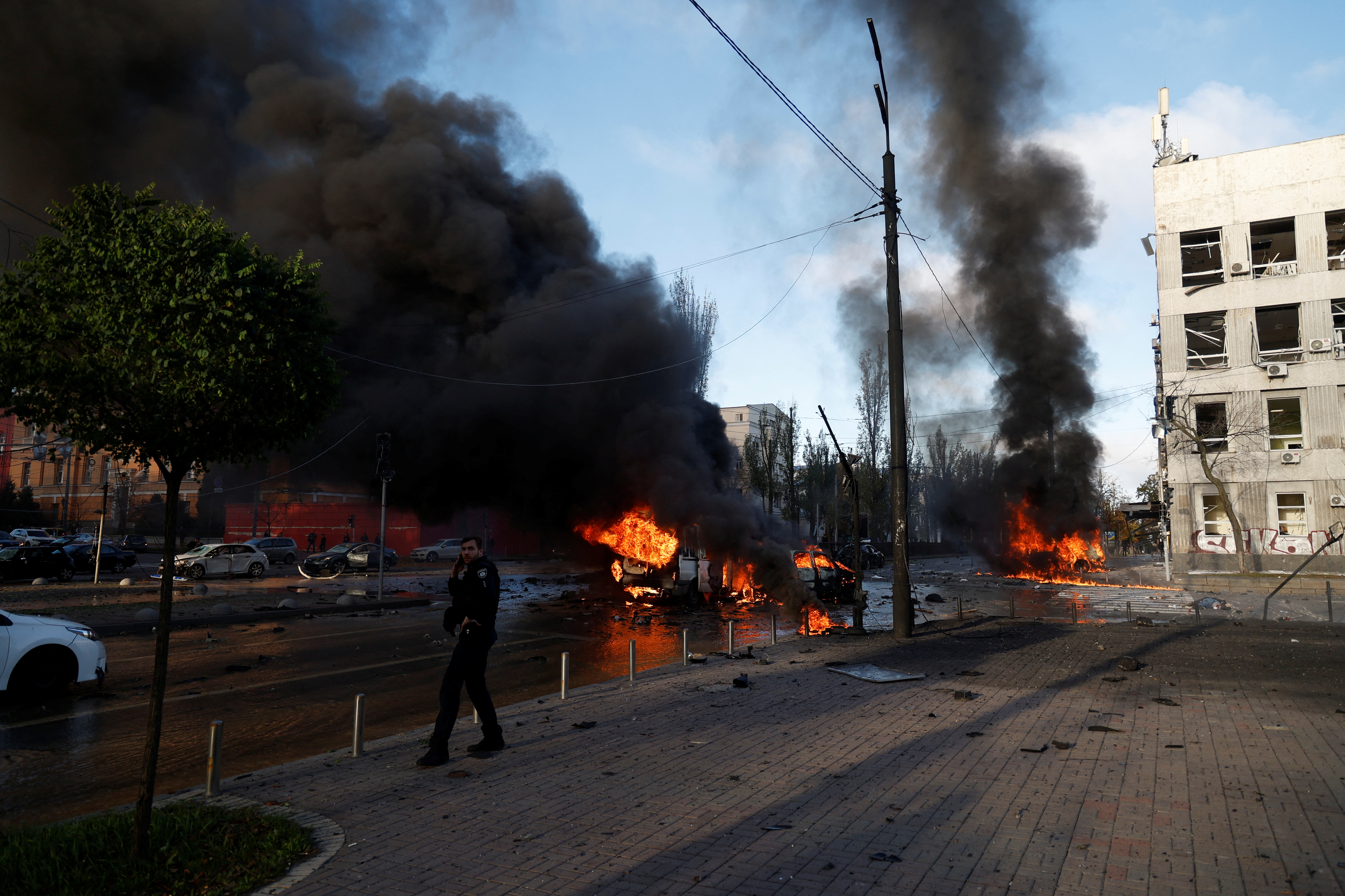 Cars are seen on fire after Russian missile strikes in Kyiv.