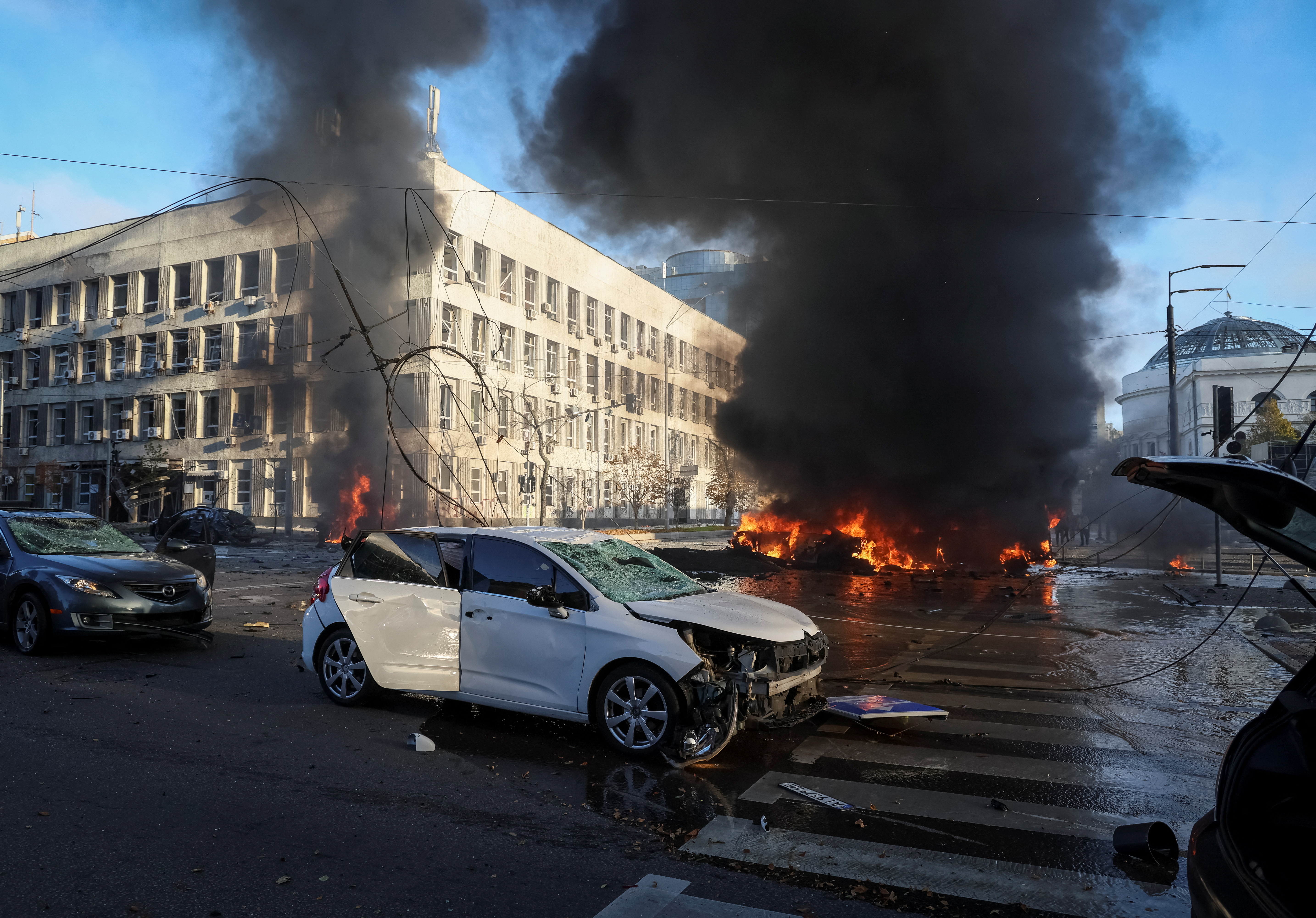 Cars burn after Russian military strike in Kyiv.