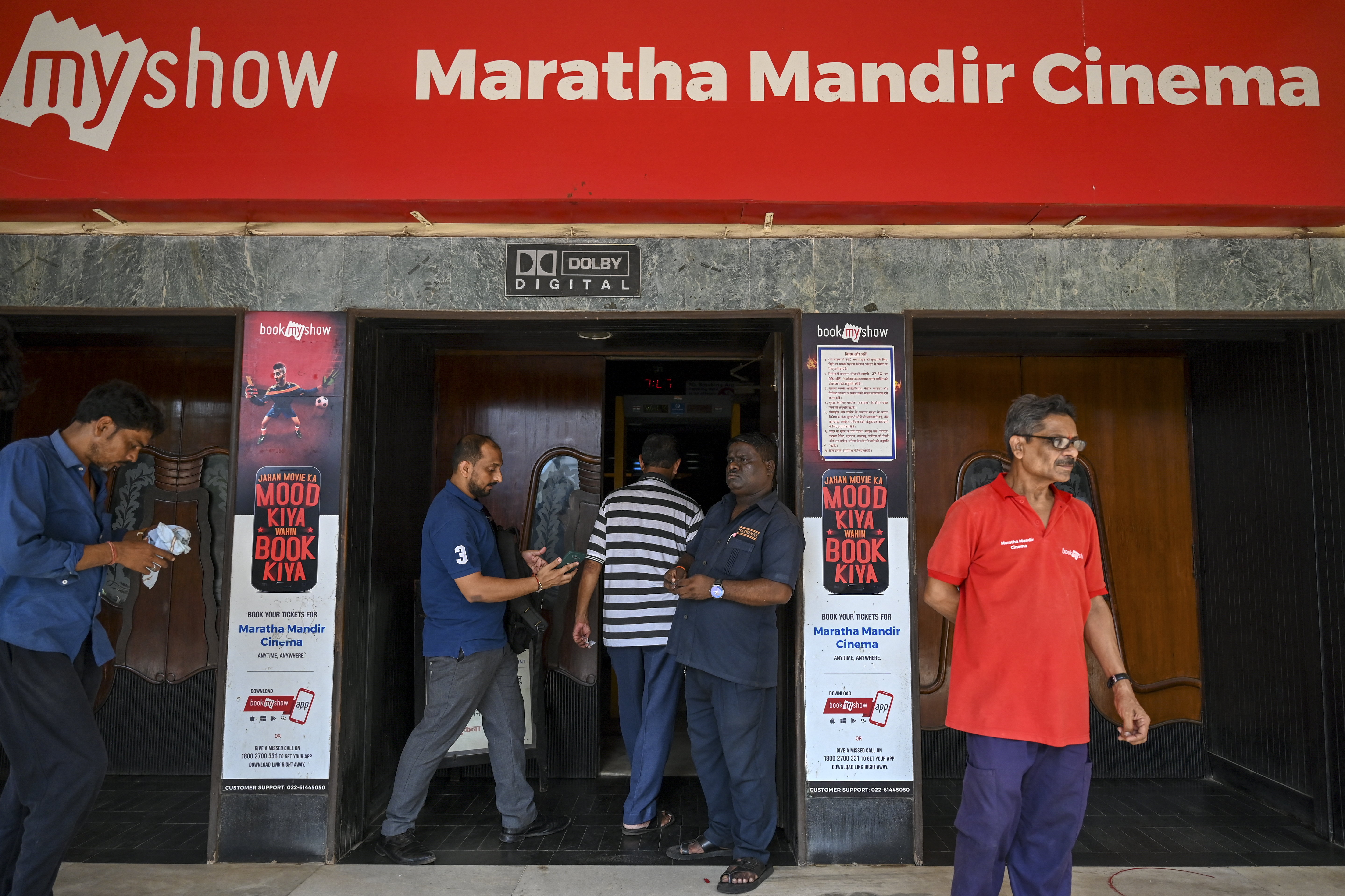 In this picture taken on September 30, 2022, people get their tickets checked before entering the Maratha Mandir Cinema Theatre in Mumbai. - India's Bollywood film industry, long part of the cultural fabric of the movie-mad country of 1.4 billion people, is facing its biggest-ever crisis as streaming services and non-Hindi language rivals steal its sparkle. (Photo by Punit PARANJPE / AFP) / To go with 'Entertainment-India-Cinema-Lifestyle-Film', FOCUS by Glenda KWEK