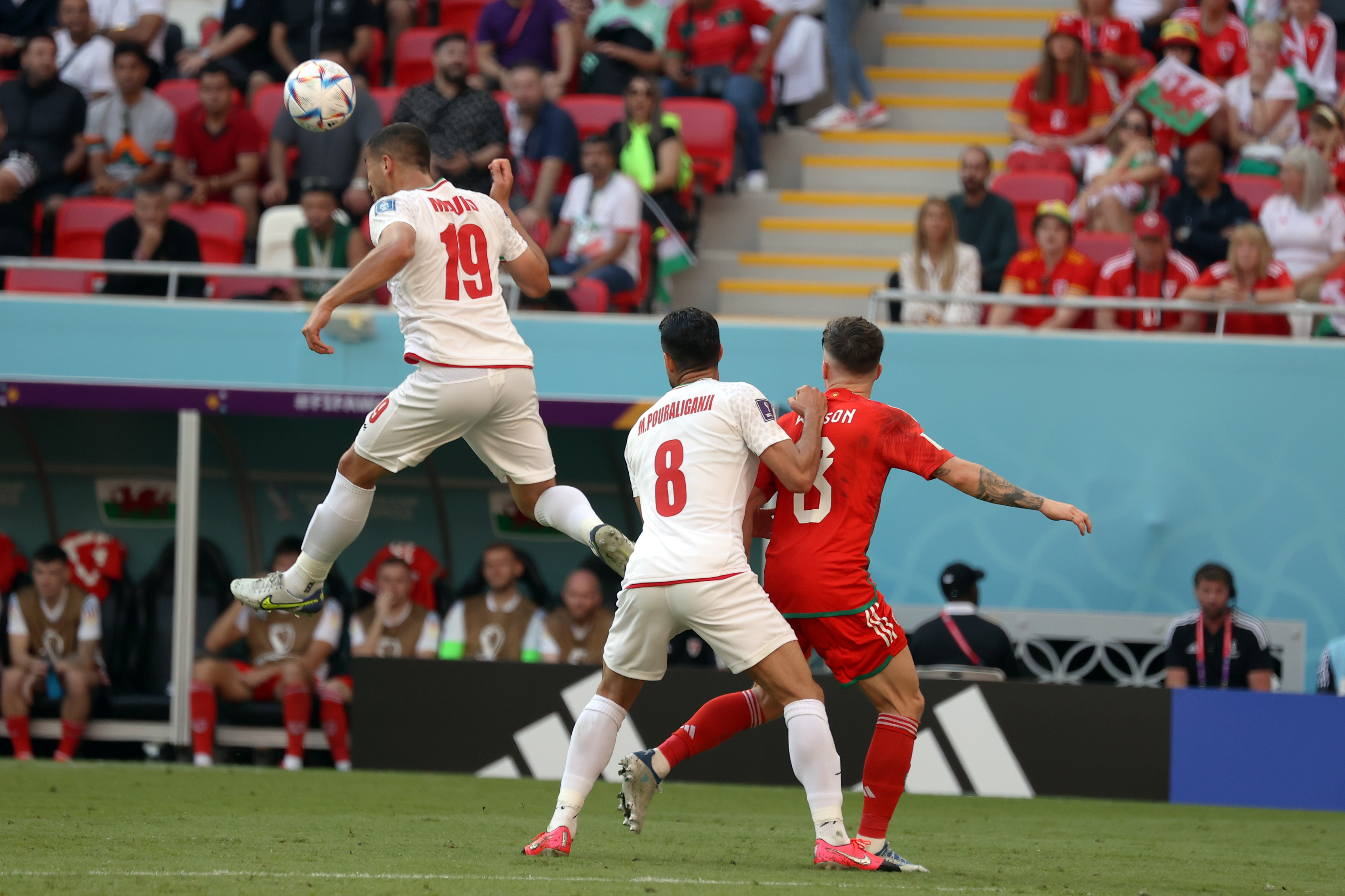 Two Iranian players tackle for the ball with a Wales footballer during their Group B, FIFA World Cup match at Ahmad bin Ali Stadium, in Al Rayyan, Qatar, on November 25, 2022