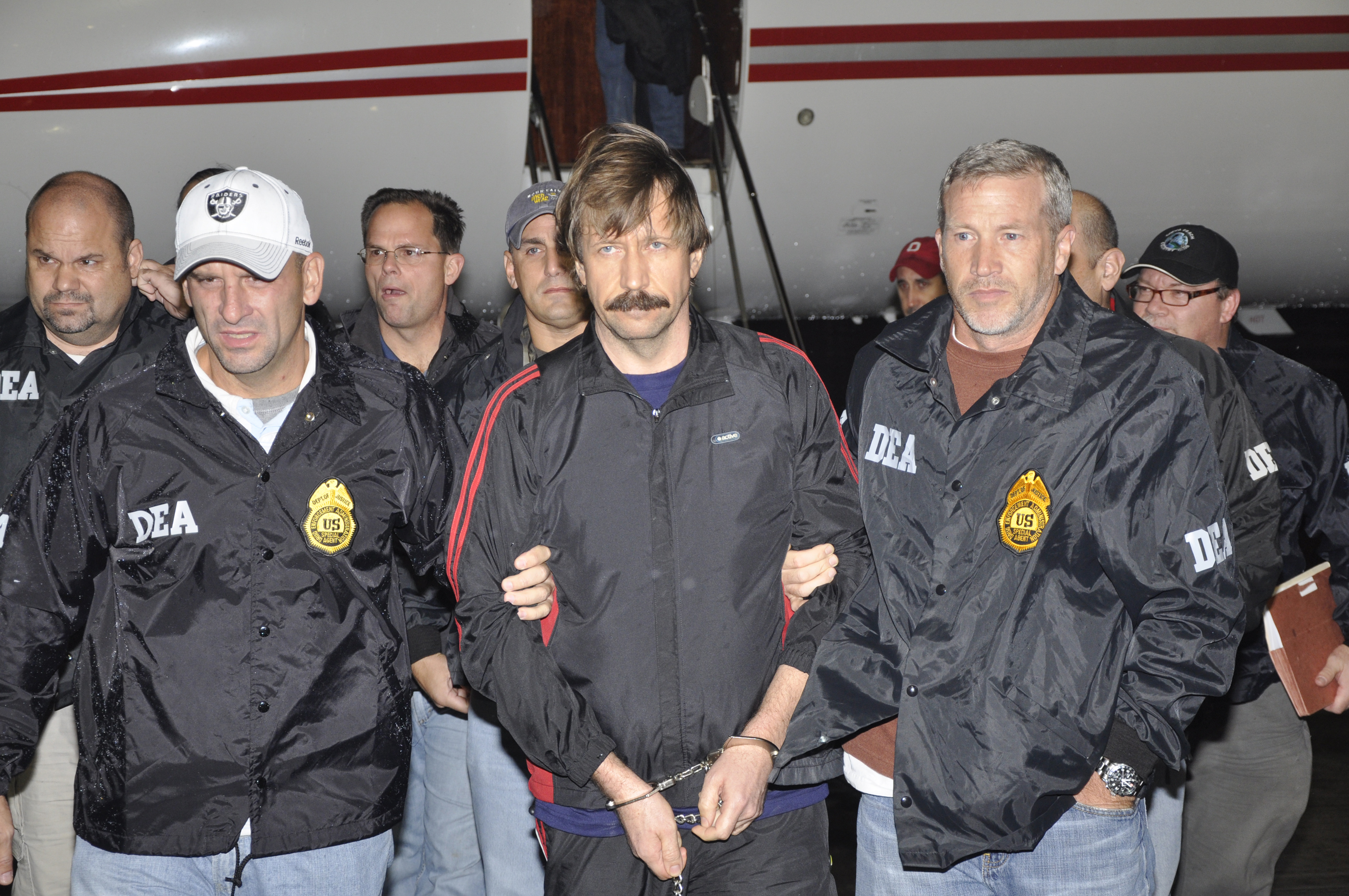 Suspected Russian arms dealer Viktor Bout (C) is escorted by Drug Enforcement Administration (DEA) officers after arriving at Westchester County Airport in White Plains, New York November 16, 2010. Bout arrived in New York from Thailand on Tuesday to face U.S. terrorism charges, the U.S. Justice Department said. REUTERS/U.S. Department of Justice/Handout (UNITED STATES - Tags: POLITICS CRIME LAW IMAGES OF THE DAY) FOR EDITORIAL USE ONLY. NOT FOR SALE FOR MARKETING OR ADVERTISING CAMPAIGNS. THIS IMAGE HAS BEEN SUPPLIED BY A THIRD PARTY. IT IS DISTRIBUTED, EXACTLY AS RECEIVED BY REUTERS, AS A SERVICE TO CLIENTS