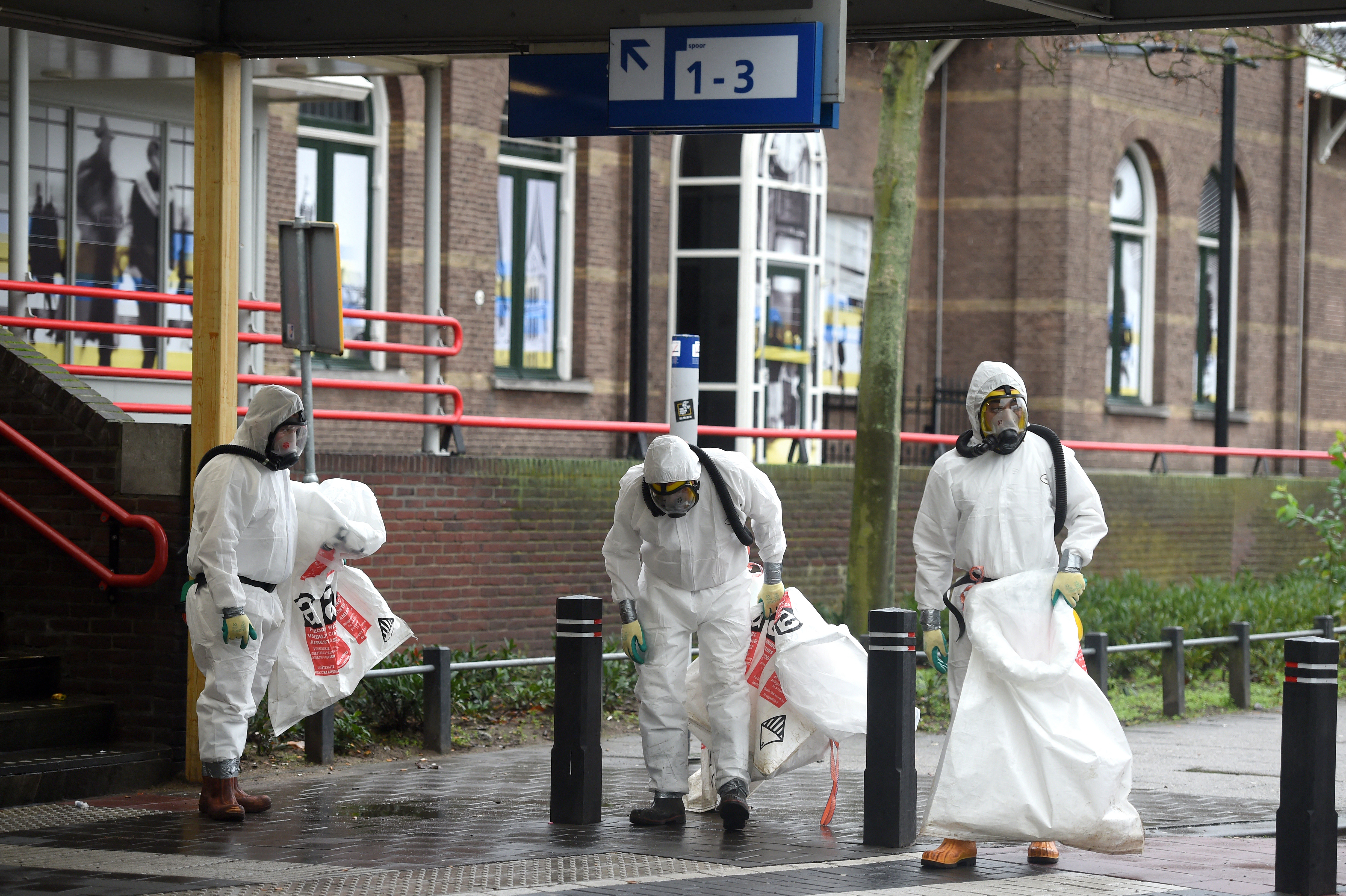 Cleaners in protective clothing search for asbestos fibres around a train station in the Netherlands. The UK’s approach to managing asbestos has been criticised for being less stringent than that of other countries