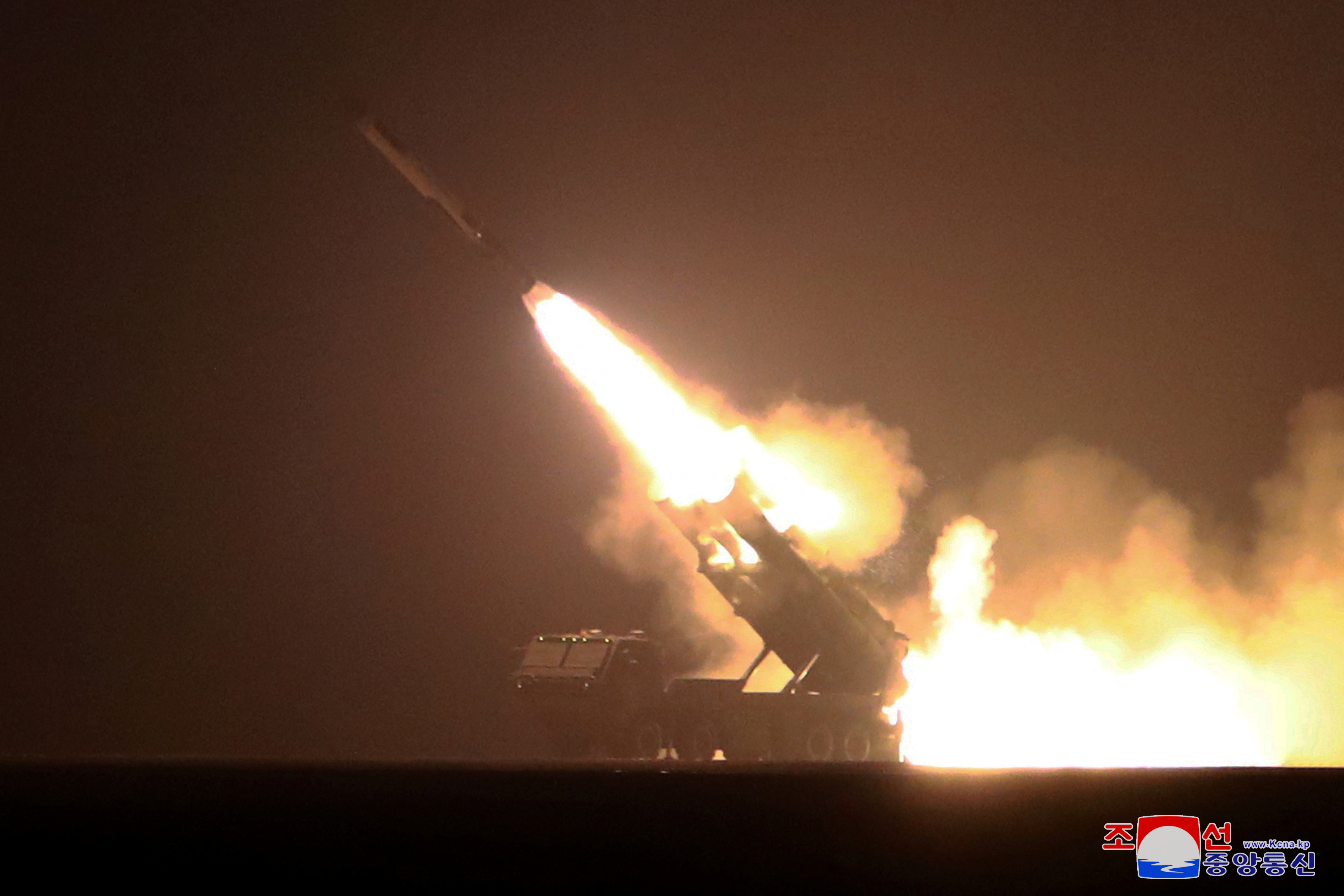 A weapon being launched into the air at night. There is lots of smoke and orange flame.