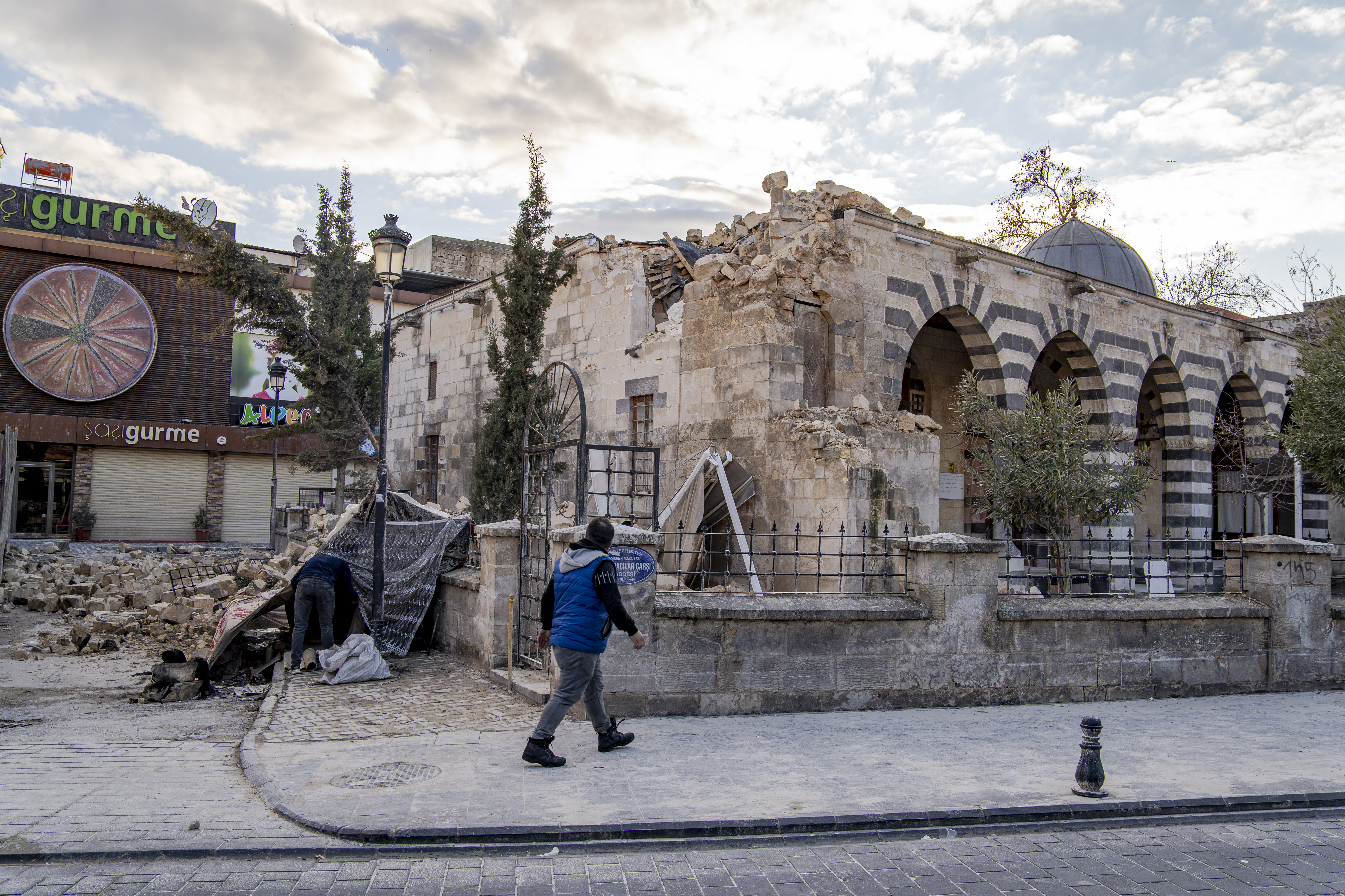 Two homeless men volunteer as guardians of the mosque after it was destroyed by the earthquake. They camped outside in a makeshift tent to keep an eye on it