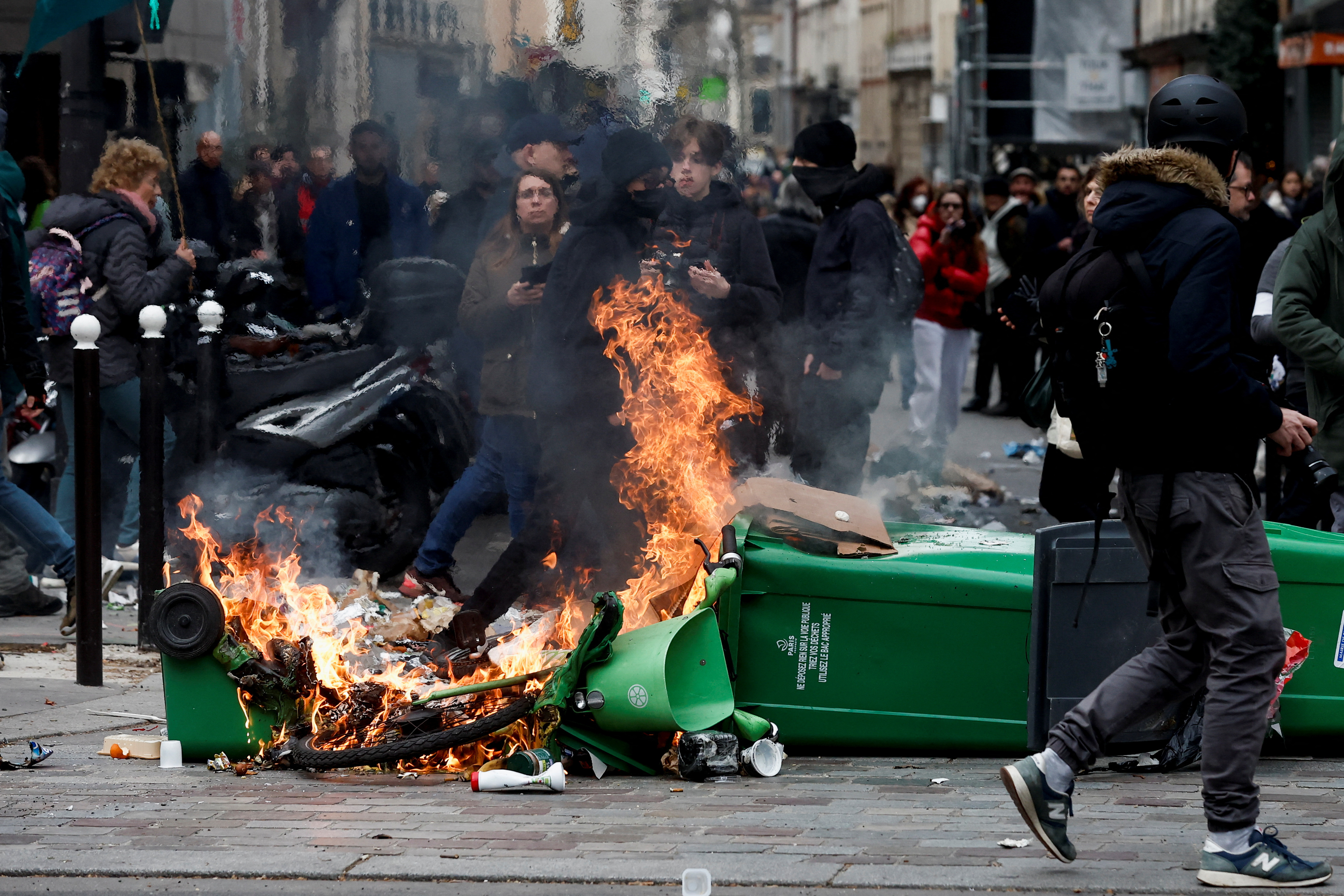 Rubbish bins set on fire as people attend a march against the government’s pension reform plan in Paris, France, March 11, 2023