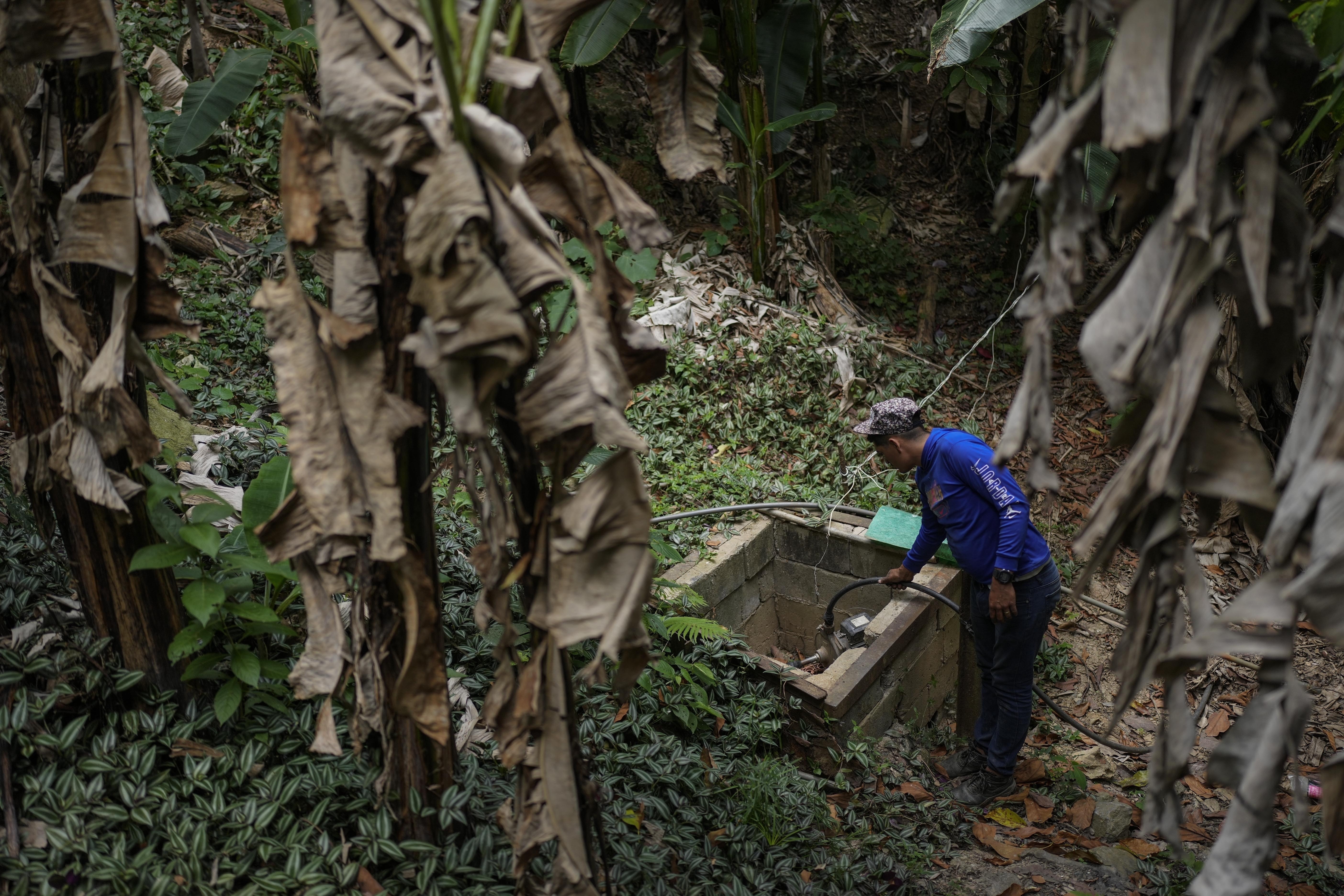 Franklin Caceres checks a water pump used to collect water from a well in the Petare neighborhood of Caracas, Venezuela,