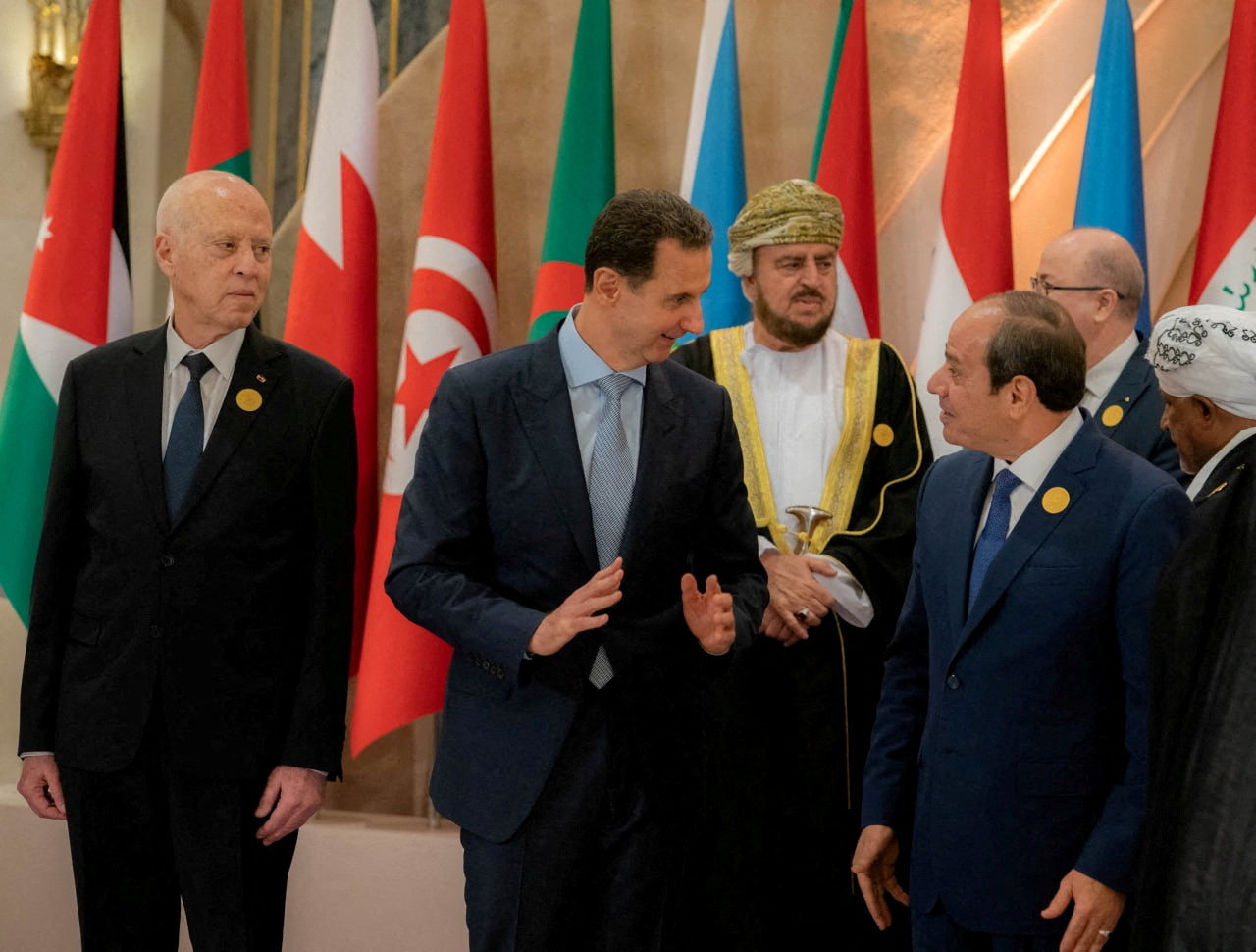 Syria's President Bashar al-Assad chats with Egypt's President Abdel Fattah al-Sisi, ahead of the Arab League summit