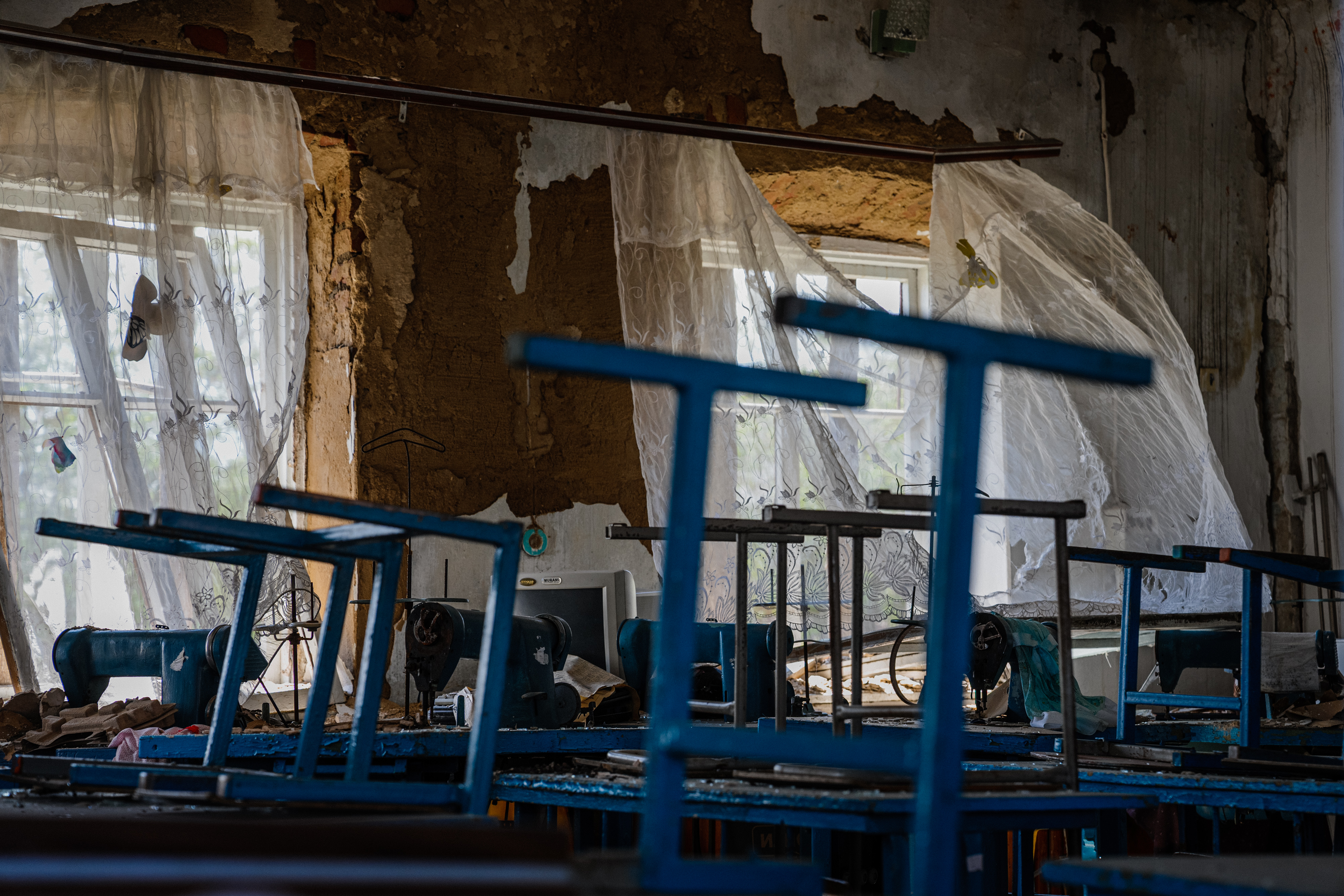 Local residents sit in a volunteer run shelter, providing access to laundry and bathroom facilities where they can warm up, charge their phones, drink hot tea and receive humanitarian aid in the town of Orikhiv, in the Zaporizhzhia region