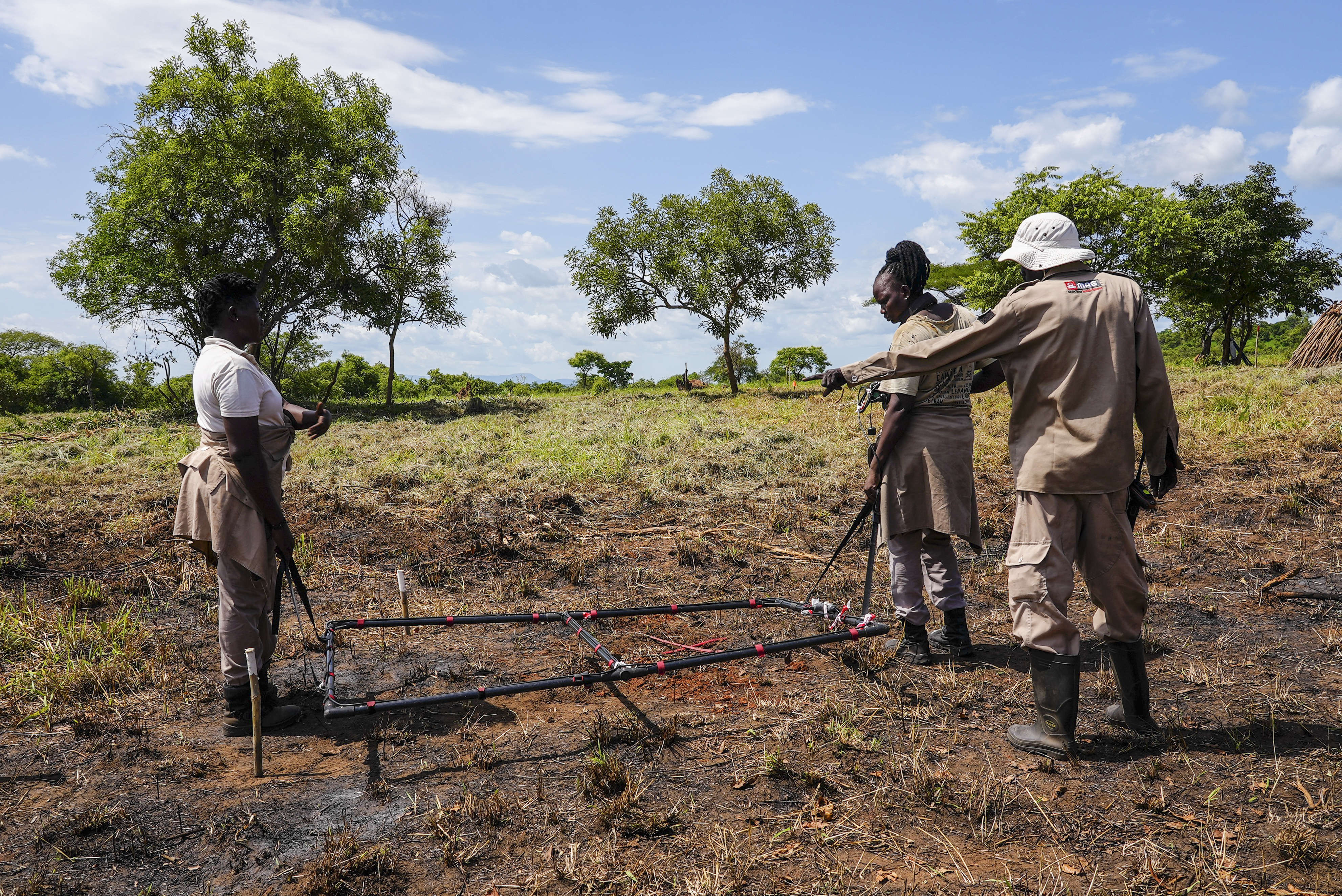 Deminers from the Mines Advisory Group (MAG) do clearance at a site containing cluster munitions in Ayii, Eastern Equatoria state