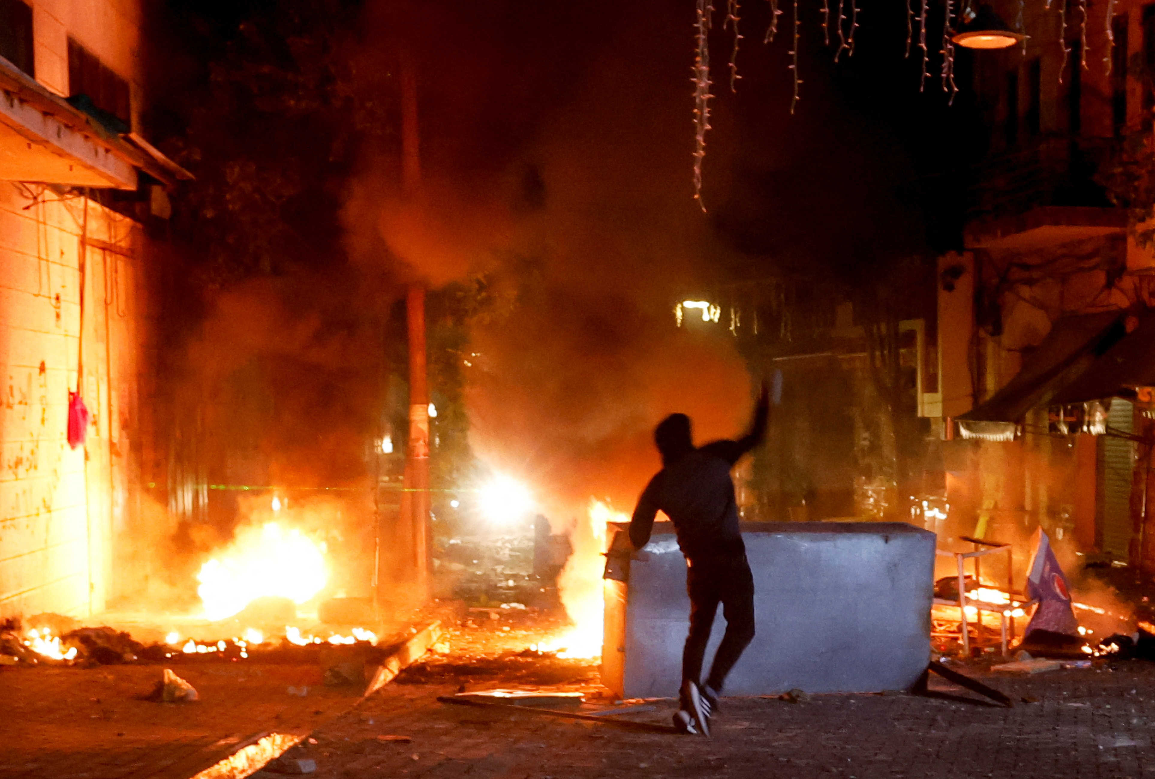 A Palestinian throws stones as the Israeli army raids Ramallah, in the Israeli-occupied West Bank, June 8, 2023. REUTERS/Mohammed Torokman