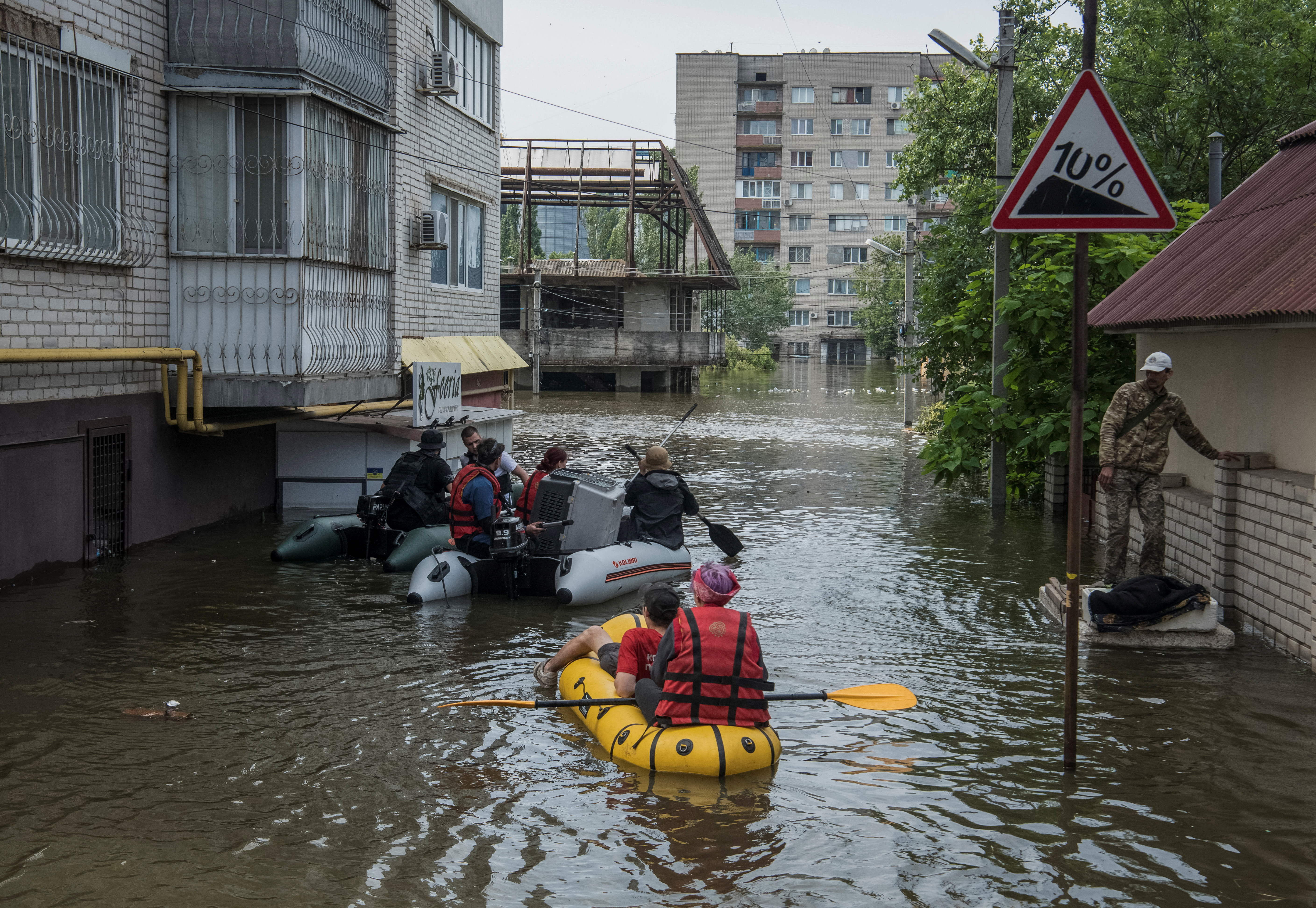 Residents sail on boats on a flooded street