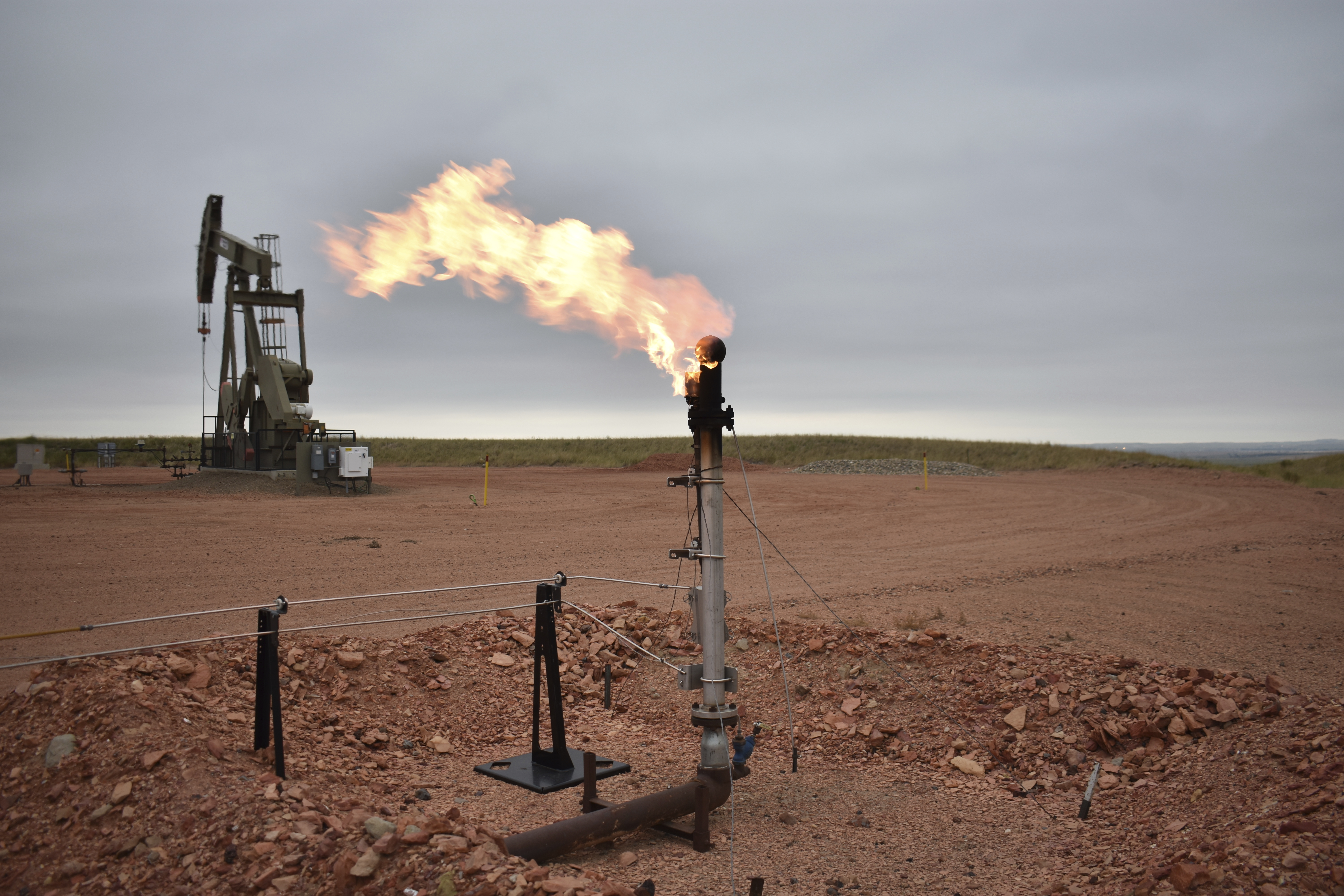 A flare for burning excess methane, or natural gas, from crude oil production is seen at a well pad in Watford City, N.D., Aug. 26, 2021. (AP Photo/Matthew Brown)