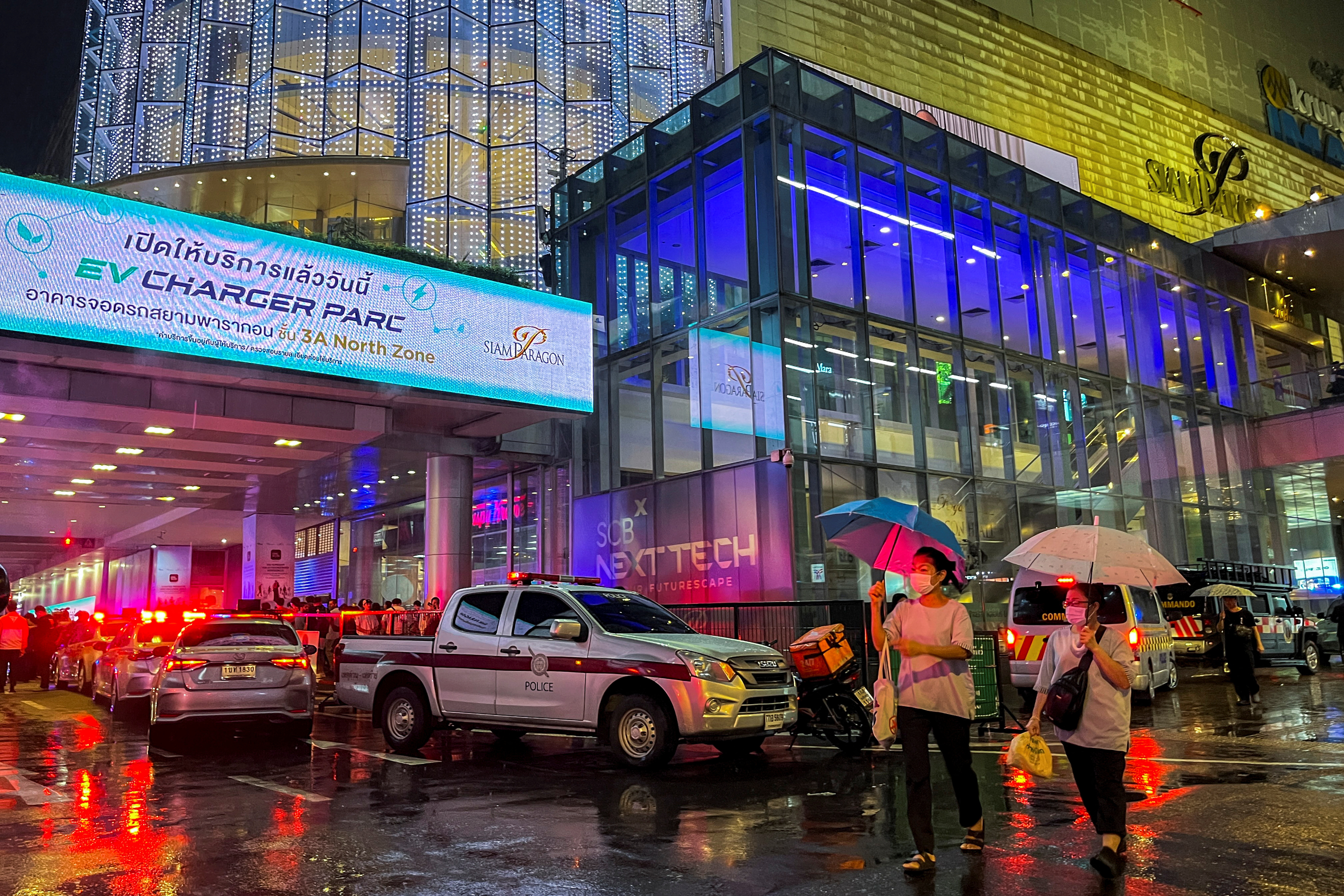 People flee following shots fired at the luxury Siam Paragon shopping mall, in Bangkok, Thailand