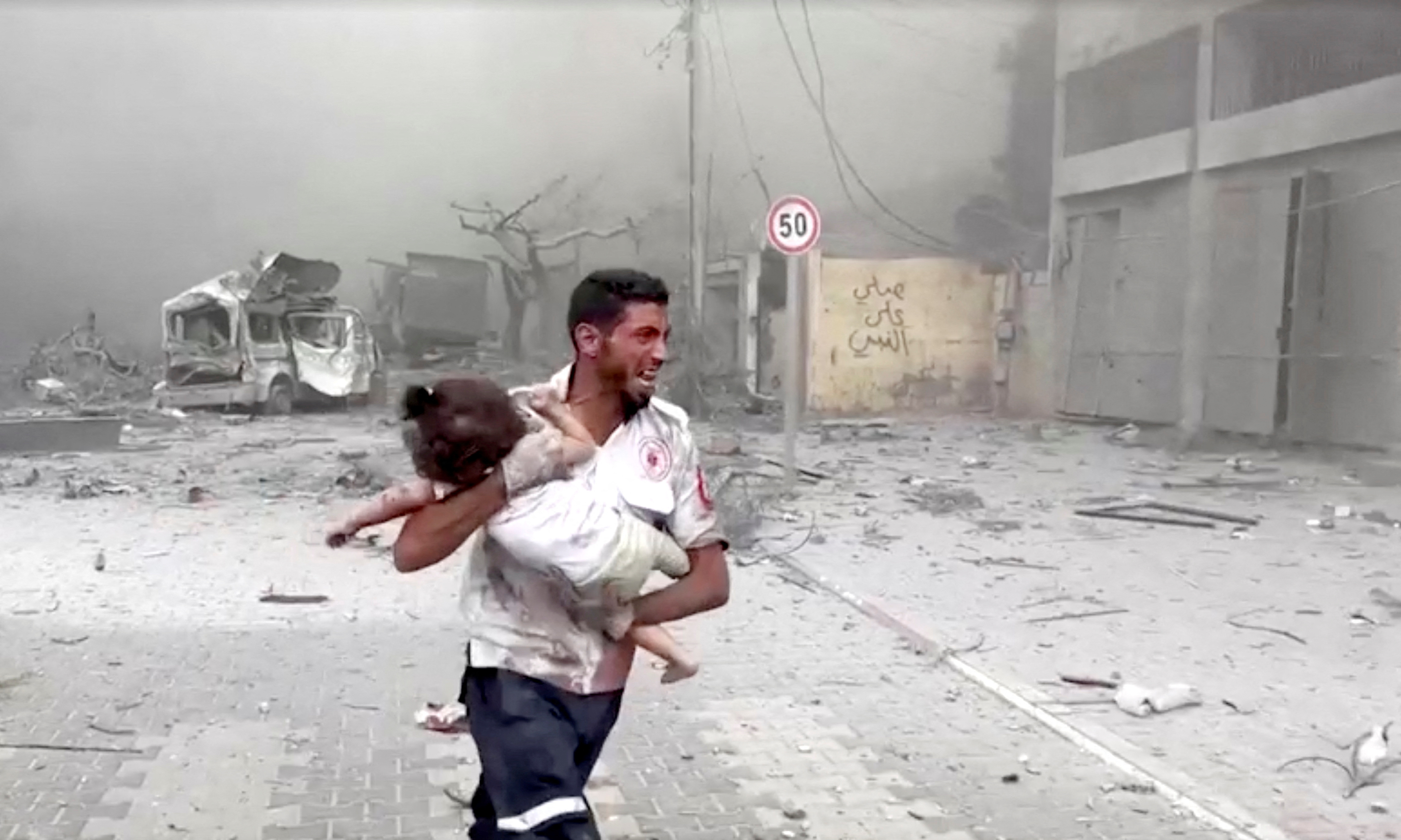 A medic runs as he carries an injured Palestinian child to ambulance in this screengrab taken from a video, in Gaza