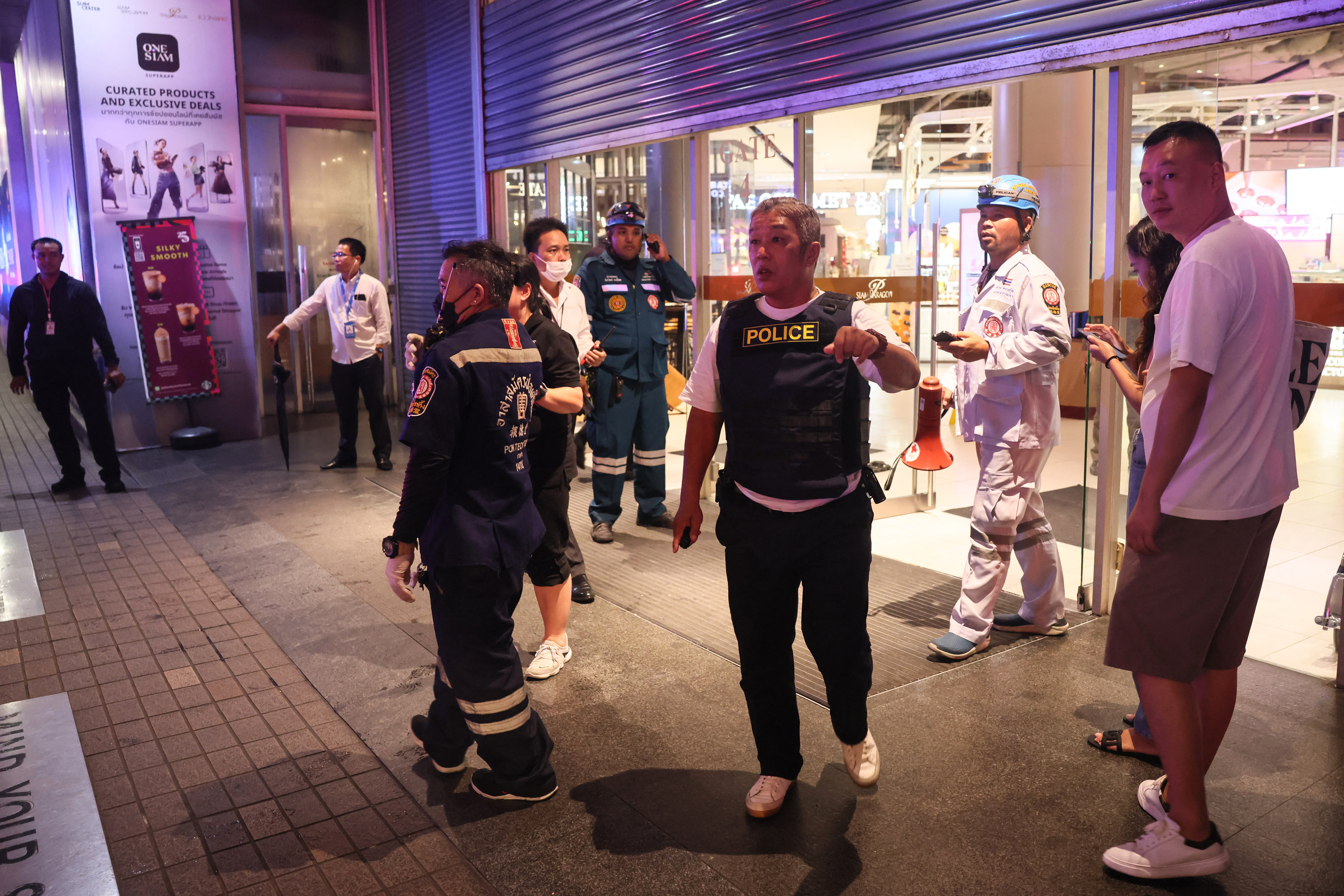 Thai police officers and rescue workers are seen outside Siam Paragon