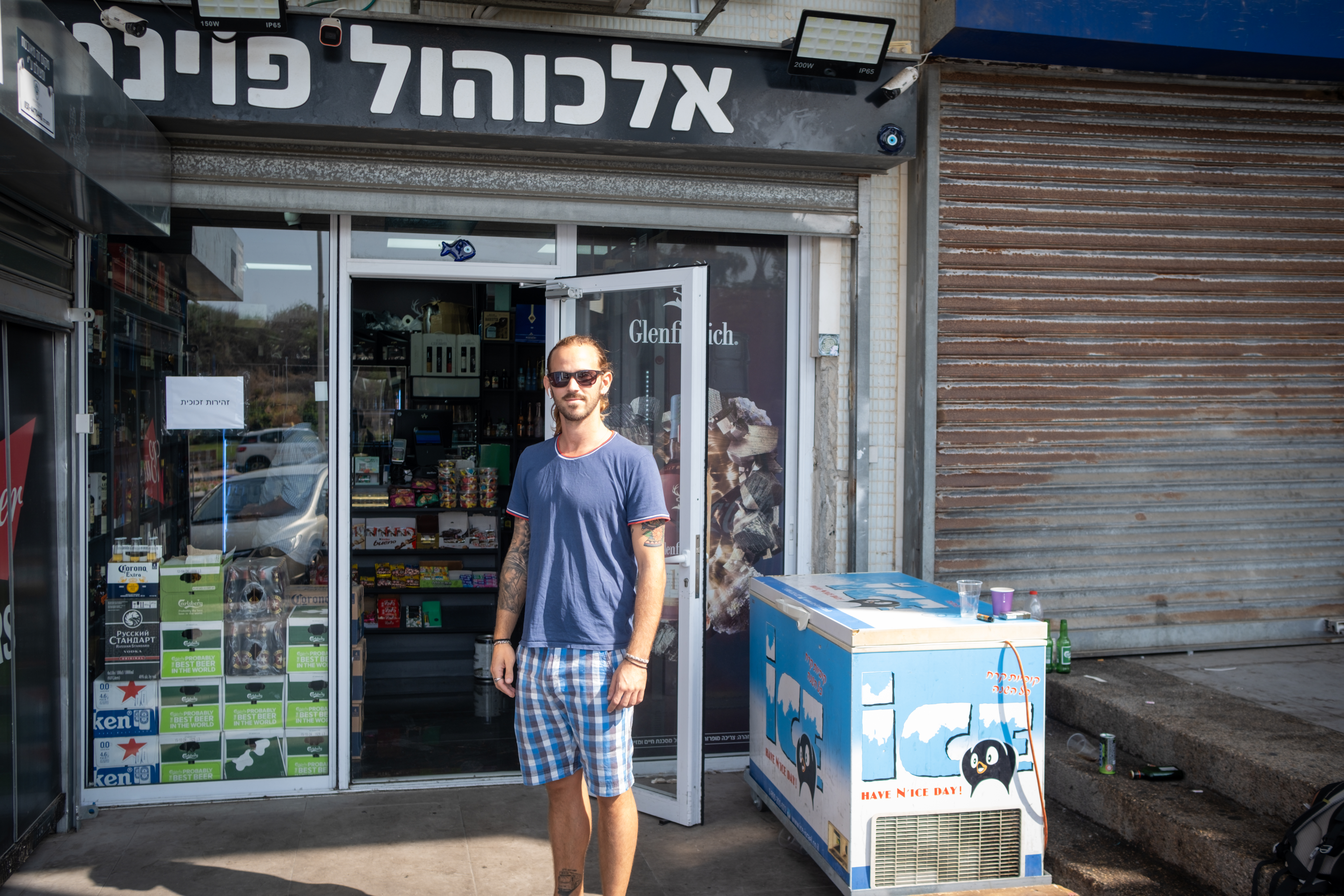 Pol Sheiman outside his shop, which faces the Gaza Strip in the distance