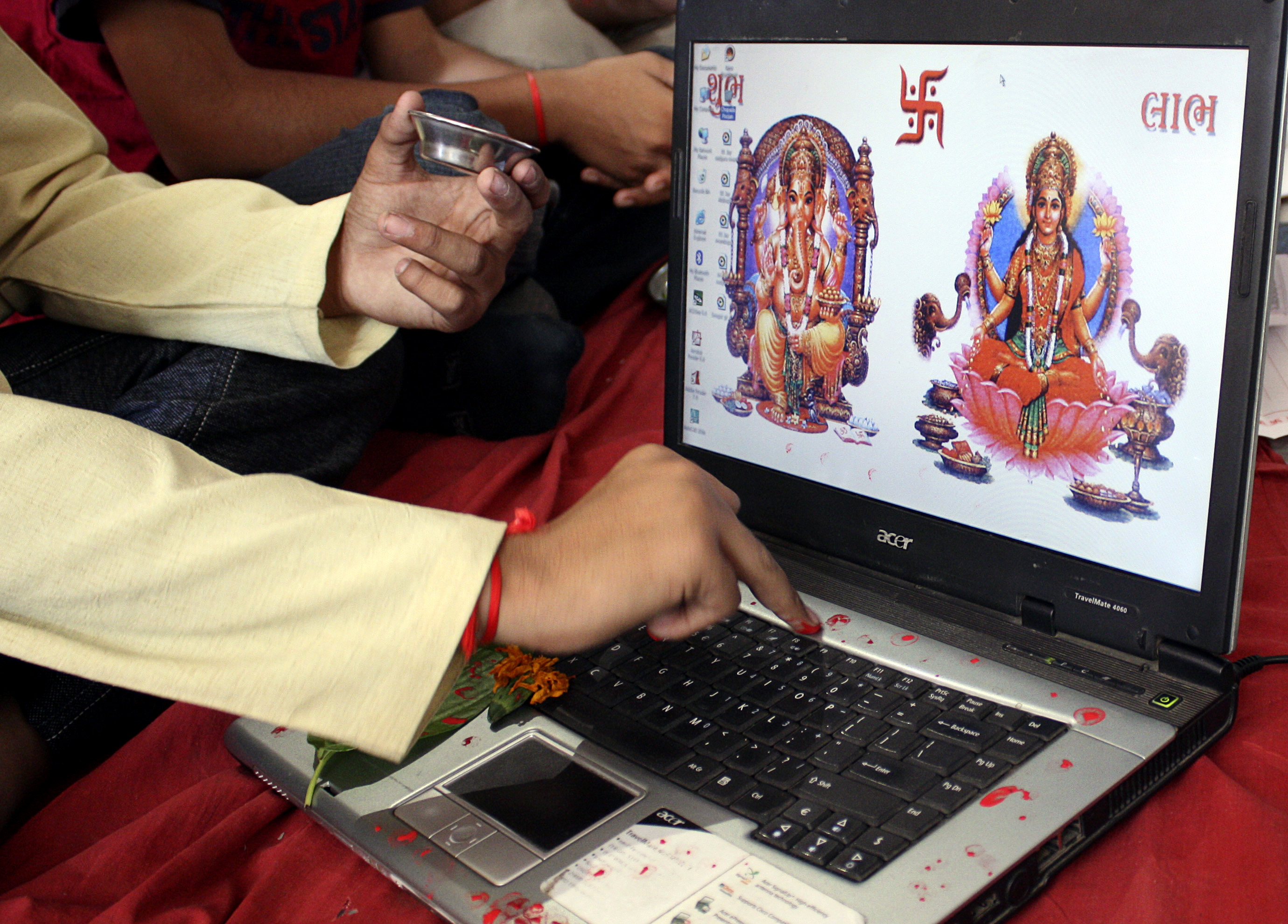 A businessman offers prayers to Hindu gods in front of a laptop as part of a ritual to worship the Hindu deity of wealth "Goddess Lakshmi" on Diwali, the Indian festival of lights, in the western Indian city of Ahmedabad October 28, 2008. The ritual known also as "Muhurat trading" is considered auspicious by traders and marks the beginning of the new trading year for the Gujarati community in India, who form the bulk of share brokers and businessmen in India. 