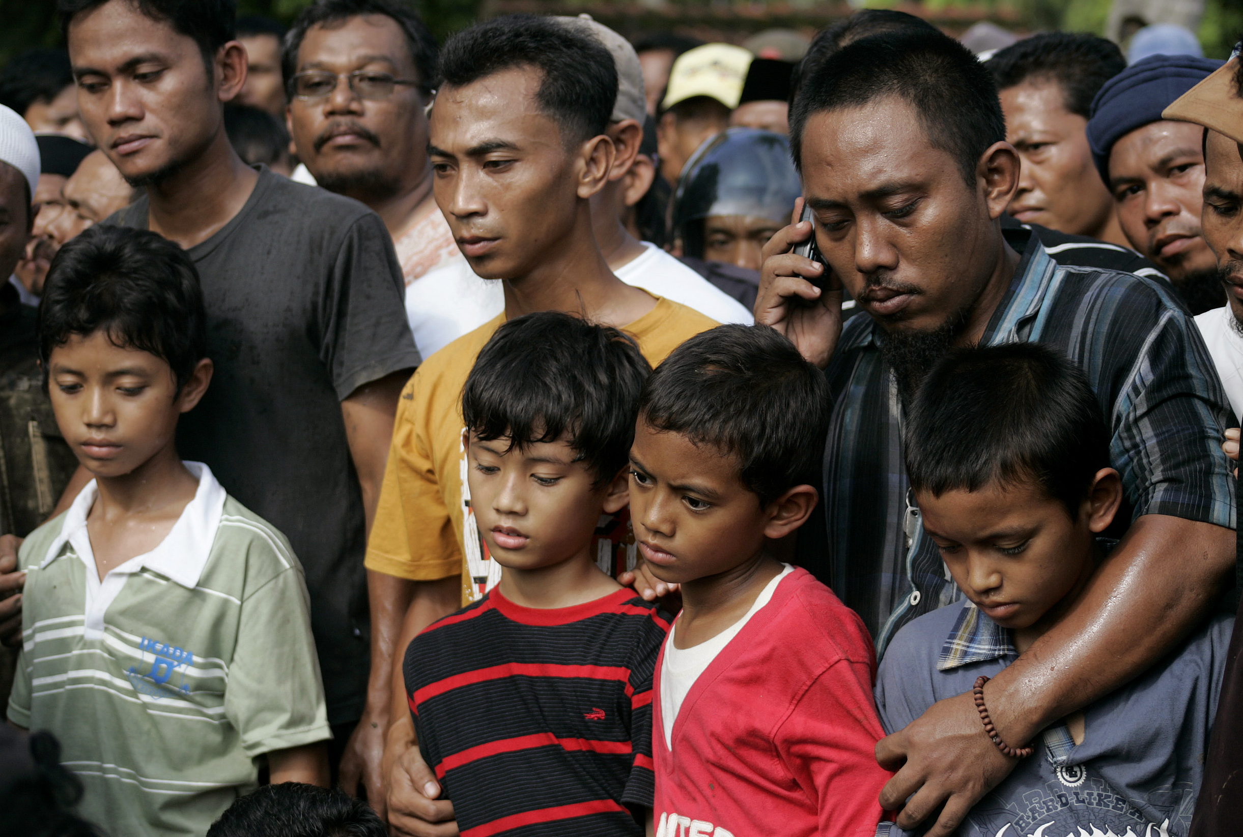 The four sons (front L-R) of militant Dulmatin, alias Joko Pitono, mourn during his funeral in Petarukan village in Indonesia's central Java province March 12, 2010. Dulmatin, a suspected mastermind of the Bali bombings, was killed in a police raid in Indonesia in the latest blow to an Islamist militant movement in the world's most populous Muslim country. REUTERS/Dadang Tri (INDONESIA - Tags: CRIME LAW)