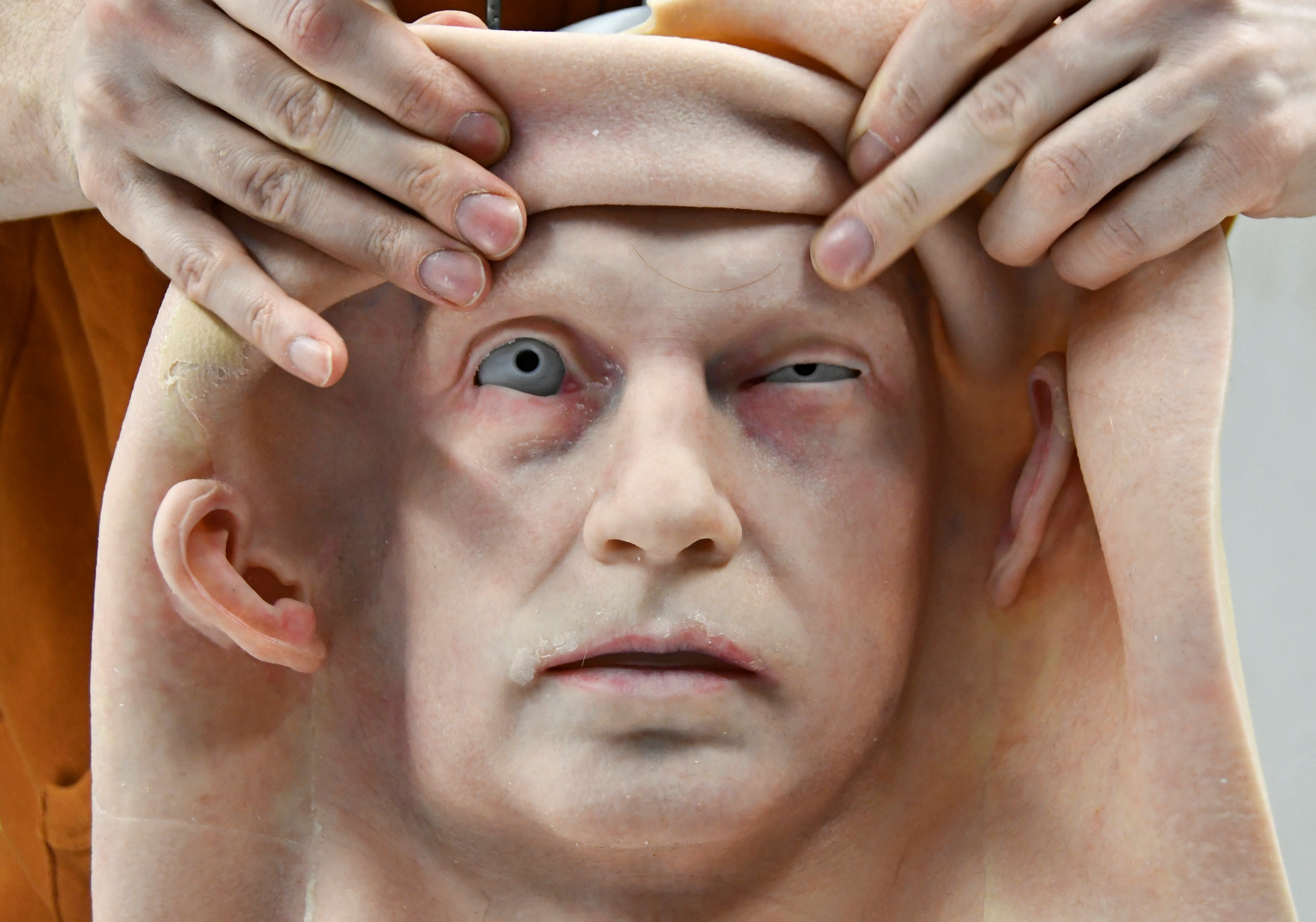 An employee attaches the skin to the head of a humanoid robot developed by Promobot service robotics manufacturer at the company's branch in the far eastern city of Vladivostok, Russia.