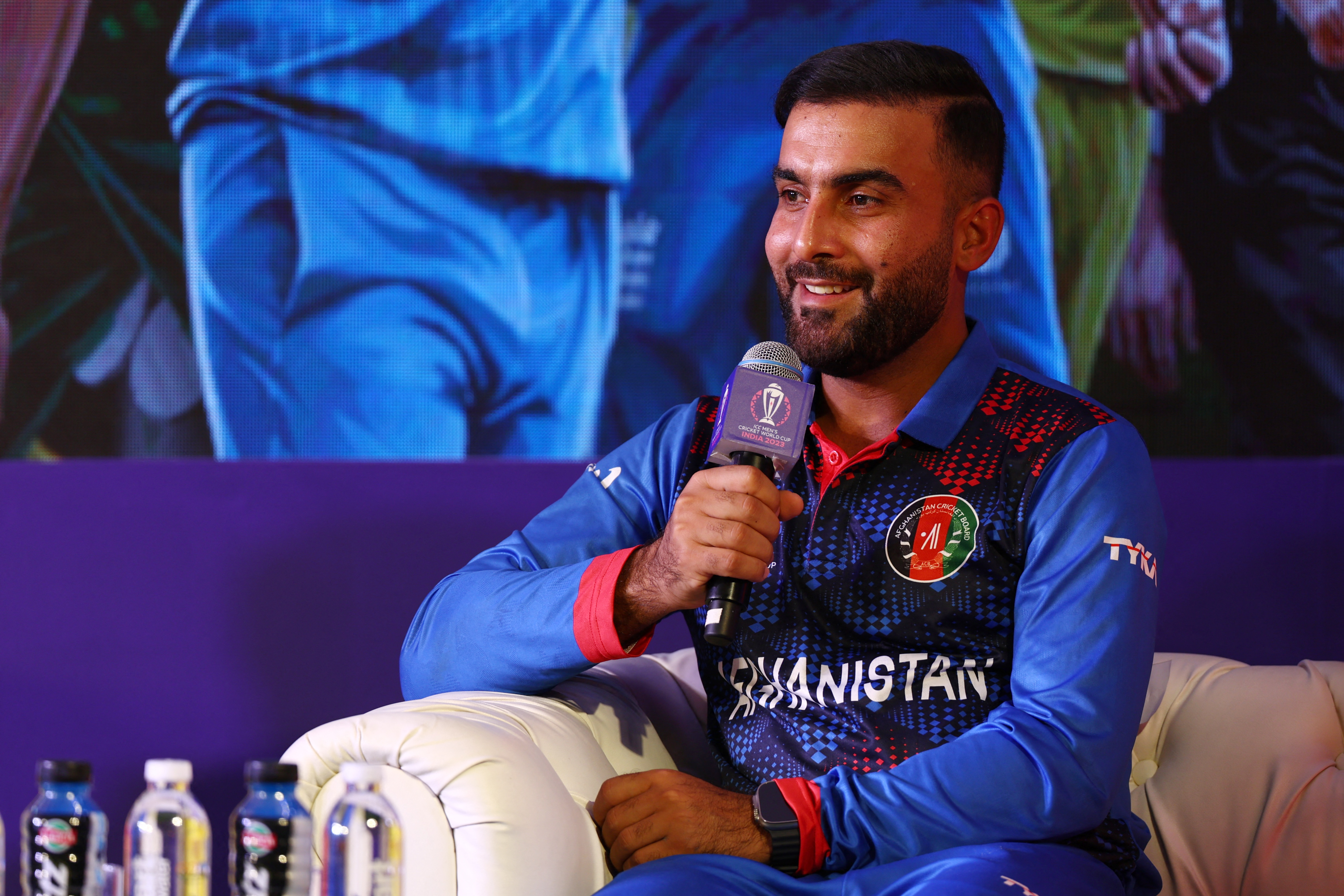 Afghanistan's Hashmatullah Shahidi speaks into a microphone