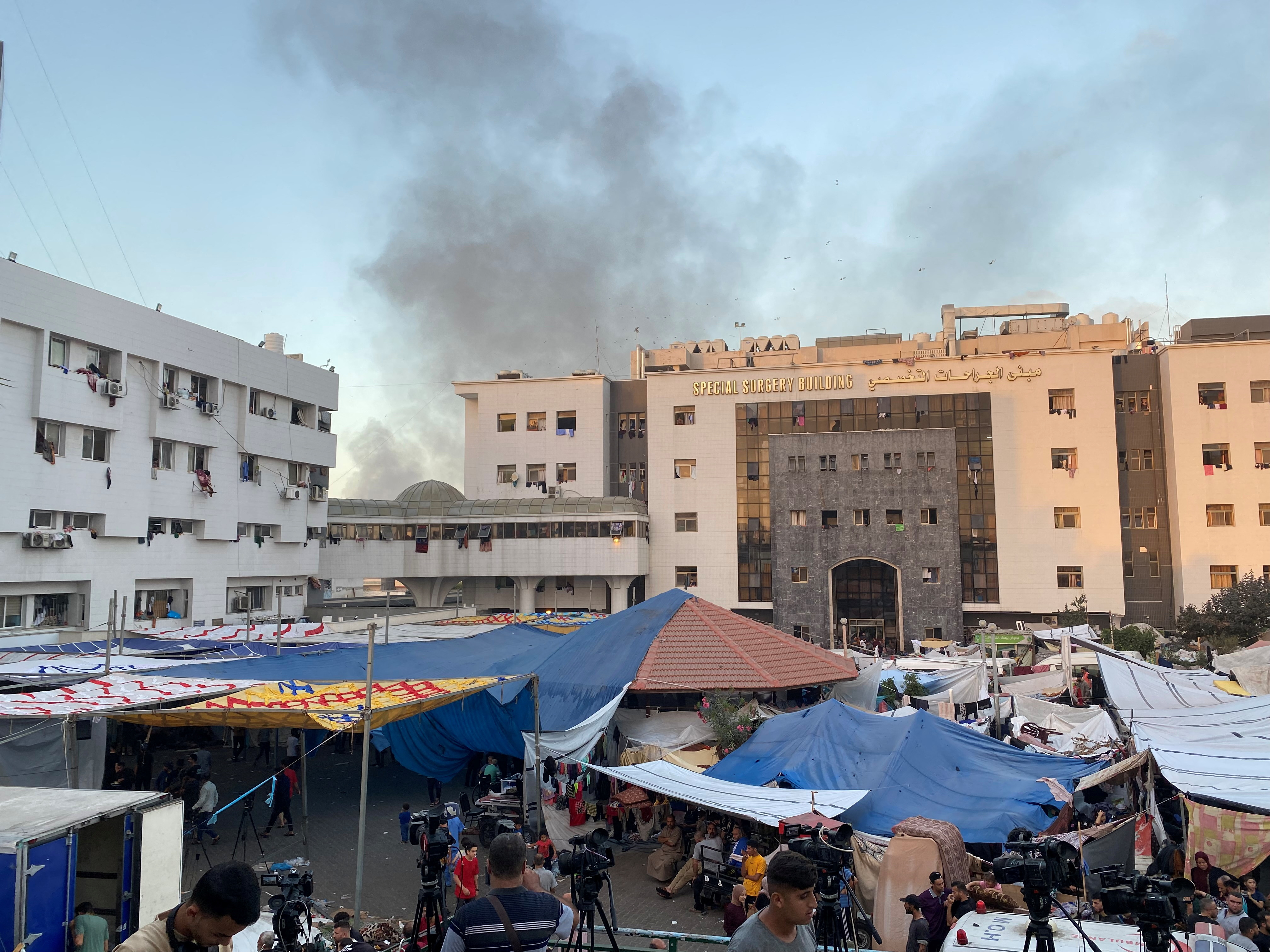 Smoke rises as displaced Palestinians take shelter at Al Shifa hospital
