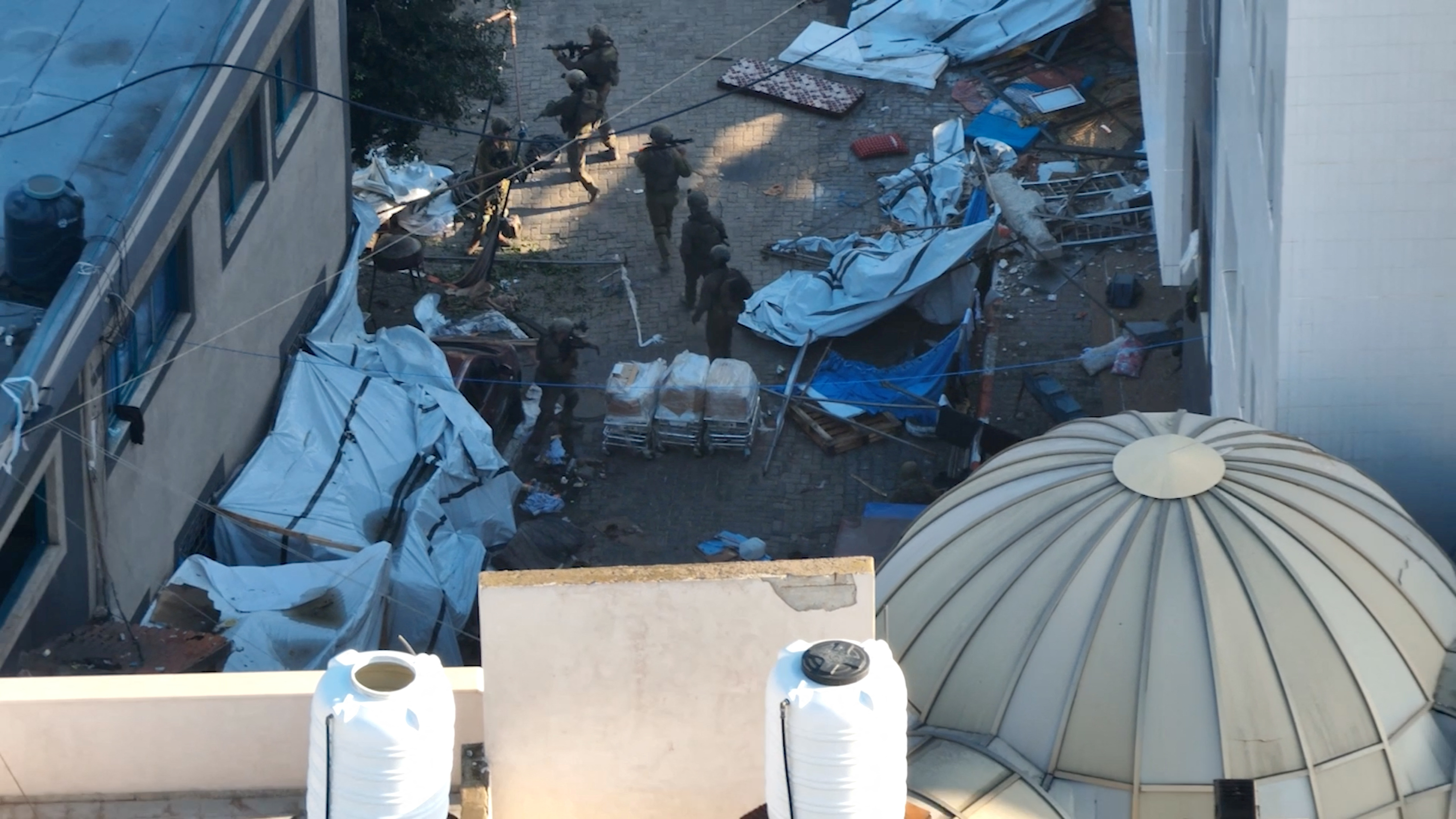 Israeli soldiers walk at the Al Shifa hospital complex