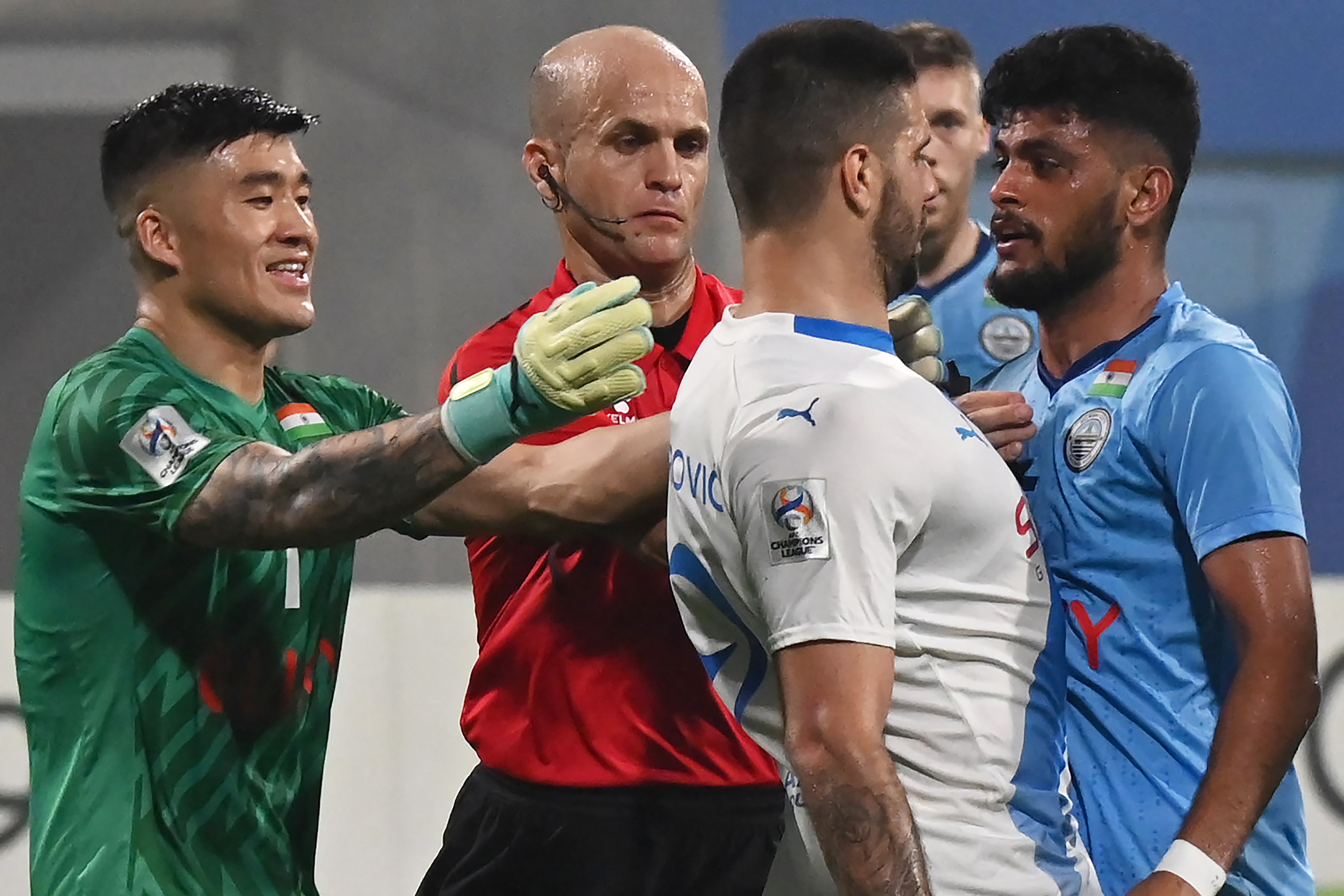 Al-Hilal SFC's forward Aleksandar Mitrovic (C) and Mumbai City FC's goalkeeper Phurba Tempa Lachenpa (L) tussel during the AFC Champions League 2023/24 Group D football match between India's Mumbai City FC and Saudi Arabias Al-Hilal SFC at the D.Y. Patil stadium in Navi Mumbai on November 6, 2023. (Photo by AFP)