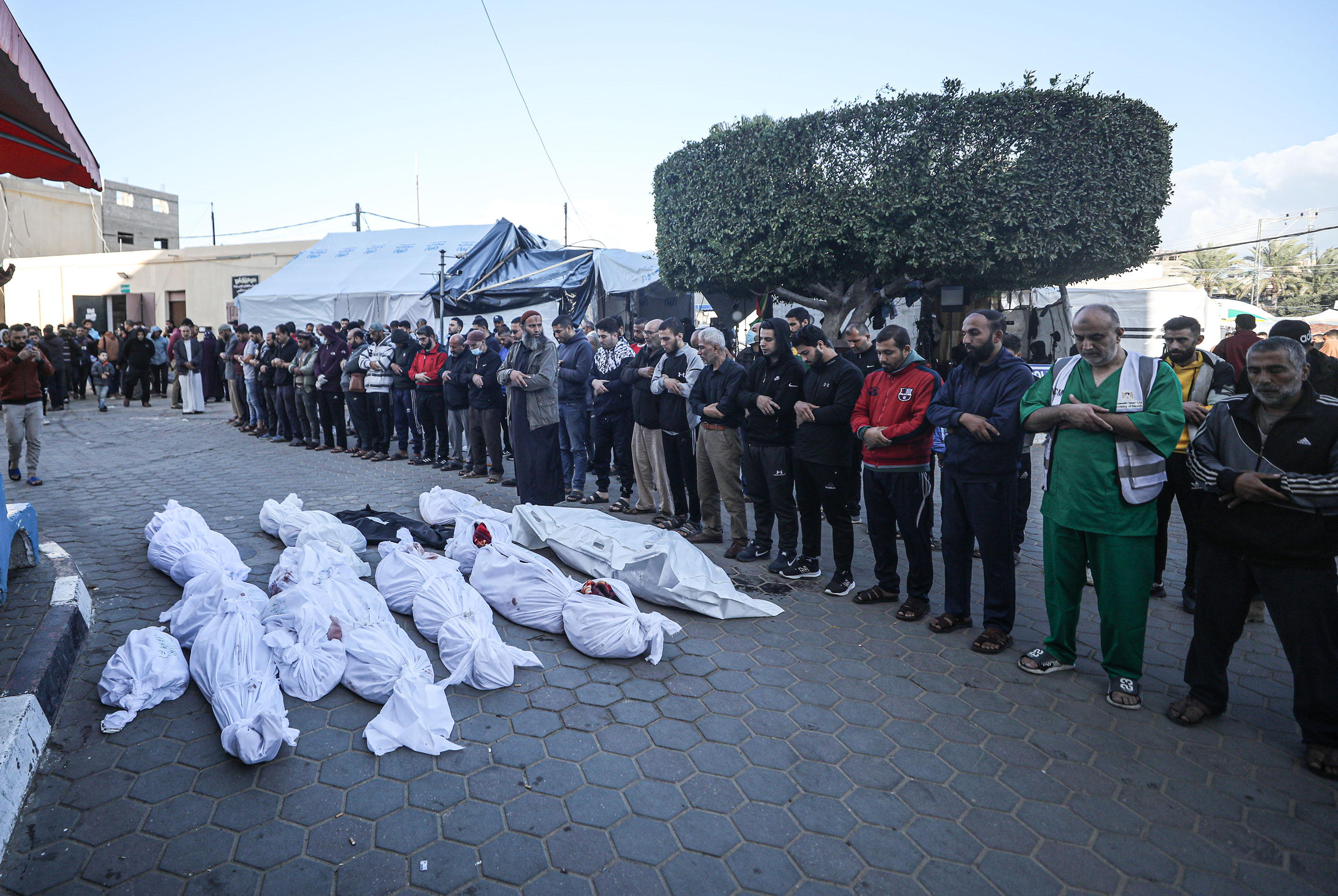 Relatives of Palestinians who lost their lives in Israeli attacks, perform funeral prayer after the bodies are taken from morgue of Al-Aqsa Martyrs Hospital to bury on the 46th day of Israeli attacks in Deir al-Balah, Gaza.