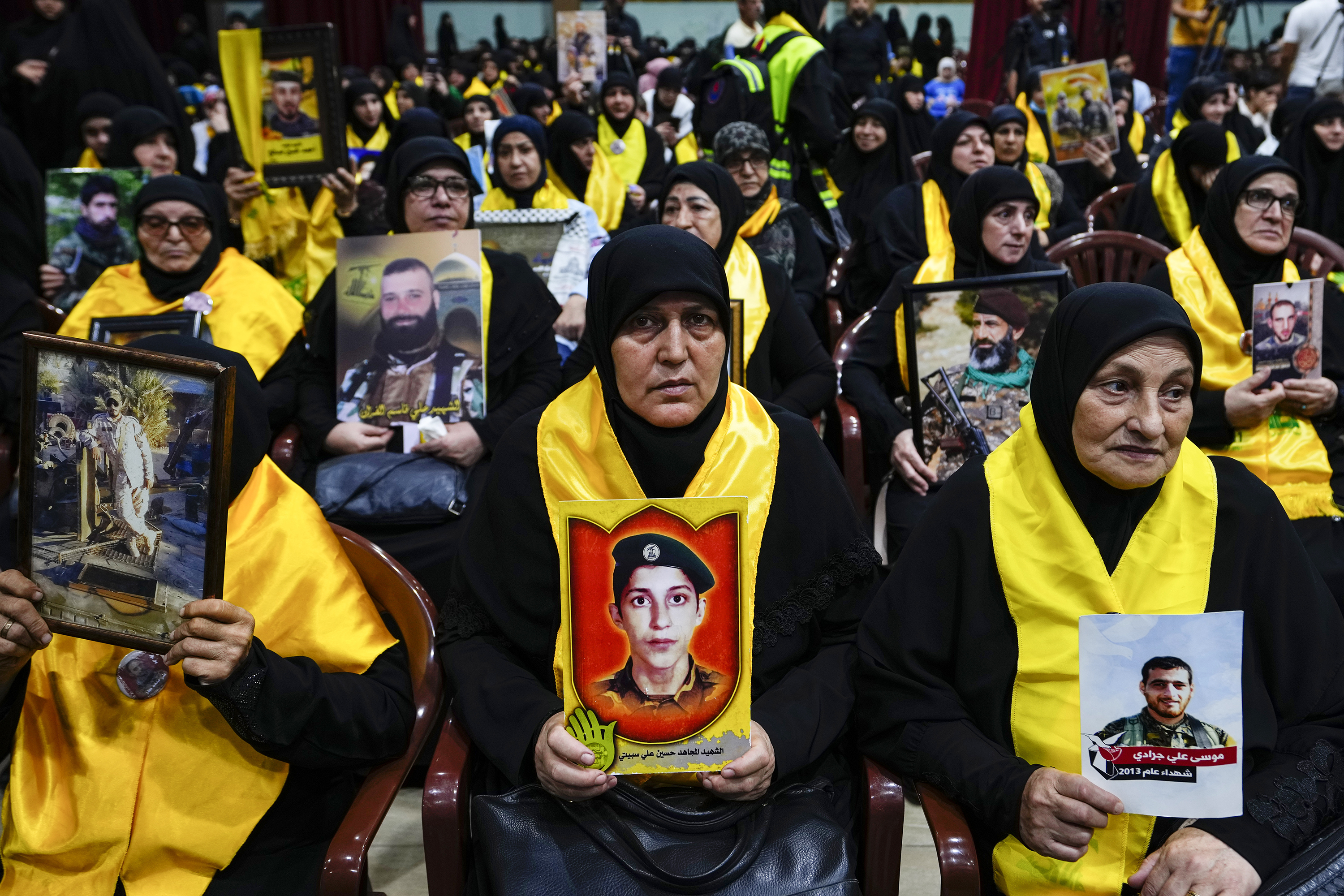 Hezbollah supporters hold pictures of their relatives who died fighting with Hezbollah as they listen to a speech of Hezbollah leader Sayyed Hassan Nasrallah via a video link, during a ceremony marking the "Hezbollah Martyr Day," in the southern Beirut suburb of Dahiyeh, Lebanon, Saturday, Nov. 11, 2023 [Hassan Ammar/AP Photo]