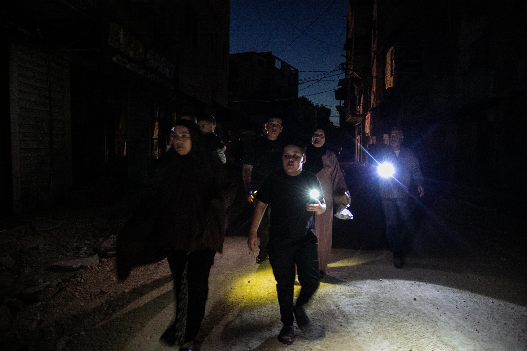 People walk on a street in Jenin