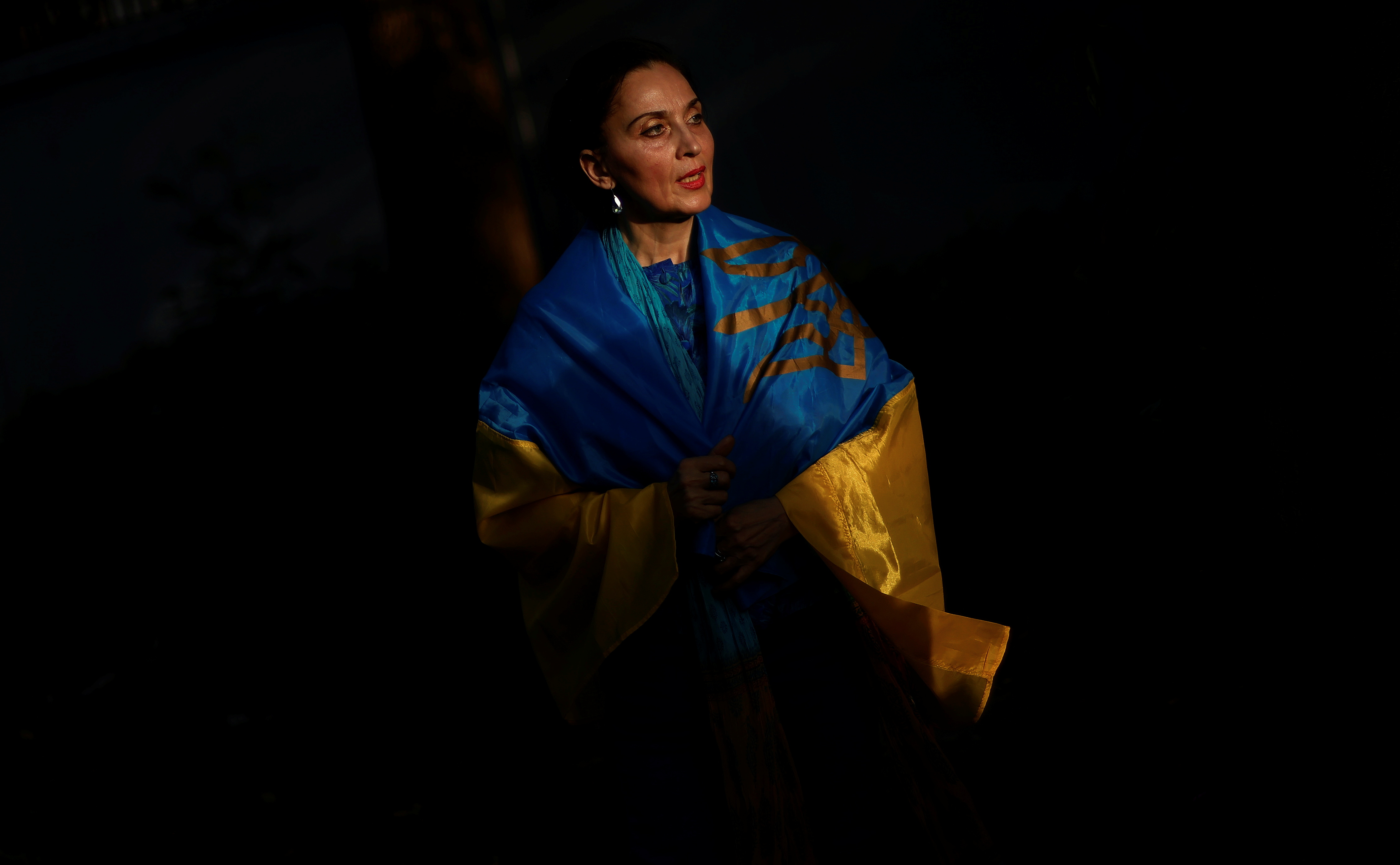 A Ukrainian citizen stands wrapped in her national flag as they gather in solidarity with their compatriots after Russia's invasion of Ukraine, at Lodhi Garden in New Delhi, India, April 1, 2022. REUTERS/Adnan Abidi