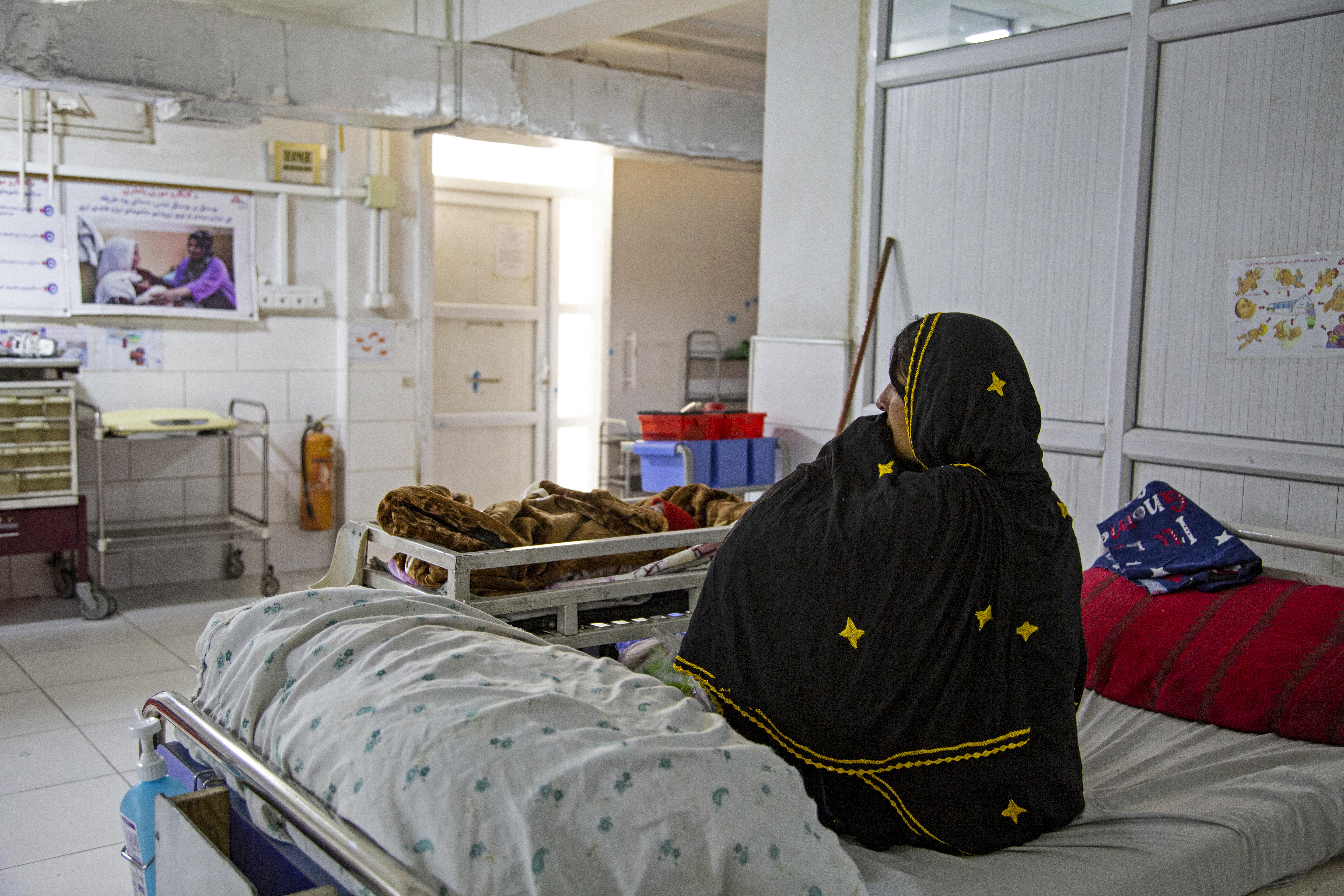 In this photograph taken on December 8, 2023, an Afghan woman sits beside her newborn child at the Doctors Without Borders (MSF)-run maternity hospital in Khost.