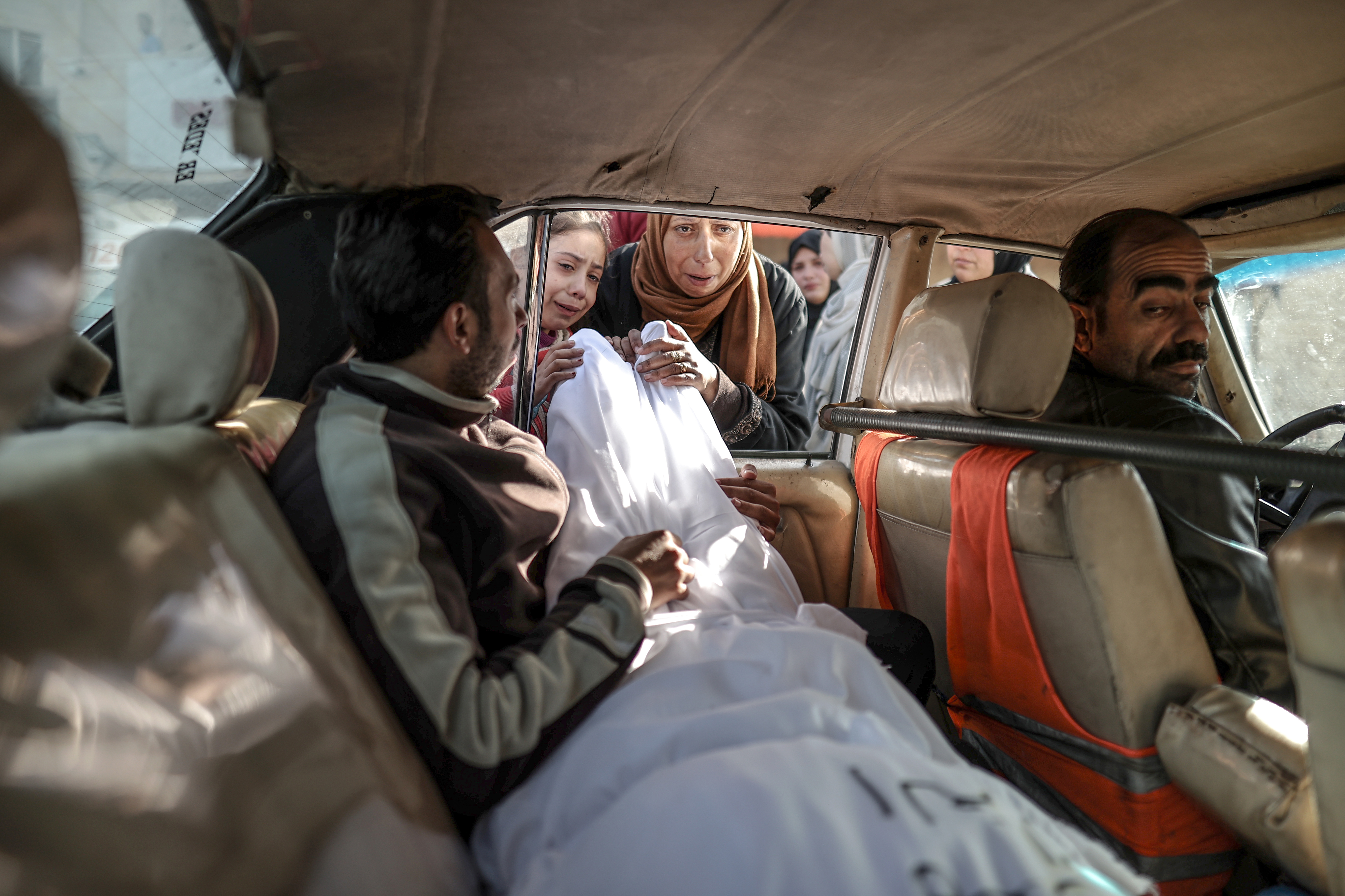 Relatives of Palestinians died in Israeli attacks mourn as they take the bodies from Al-Aqsa Martyr's Hospital's morgue for funeral ceremony in Deir al-Balah, Gaza on December 12