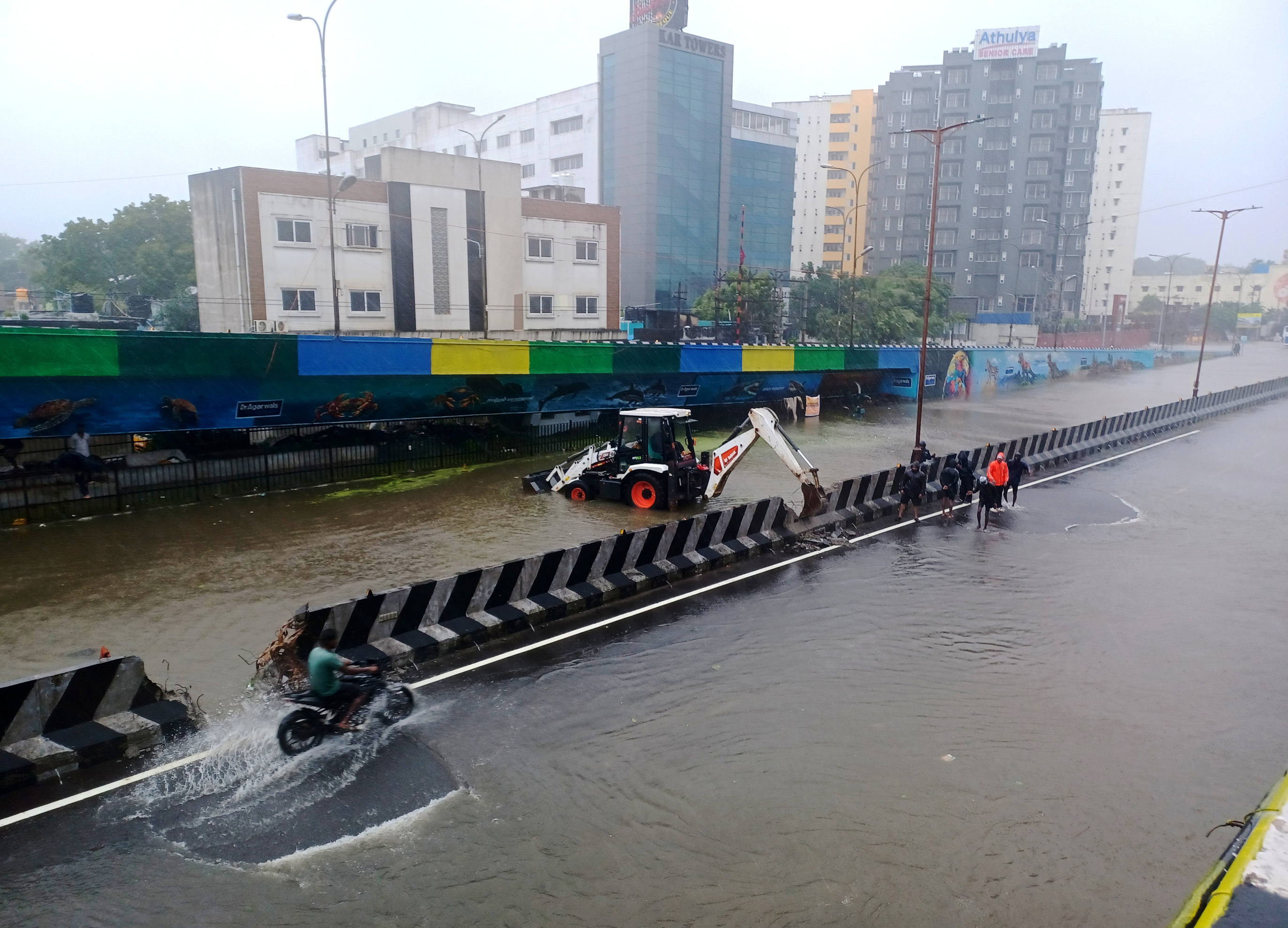 Civic workers at a flooded street following heavy rains along the Bay of Bengal coast in Chennai, India, Monday, Dec.4