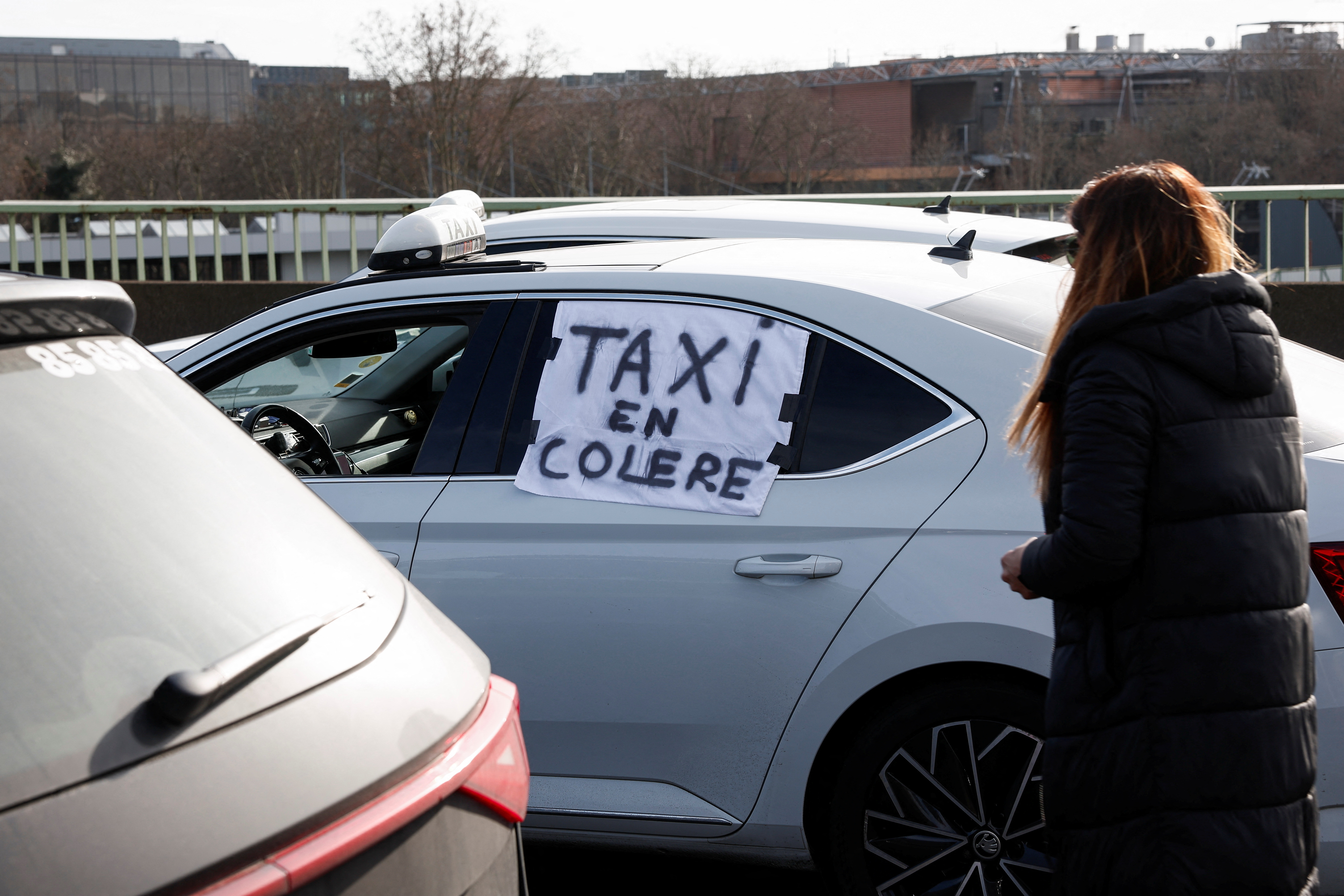 A sign reading ‘angry taxi’ is displayed on a car as French taxi drivers block a ring road to demand a renegotiation of the remuneration conditions for patient transport in Paris