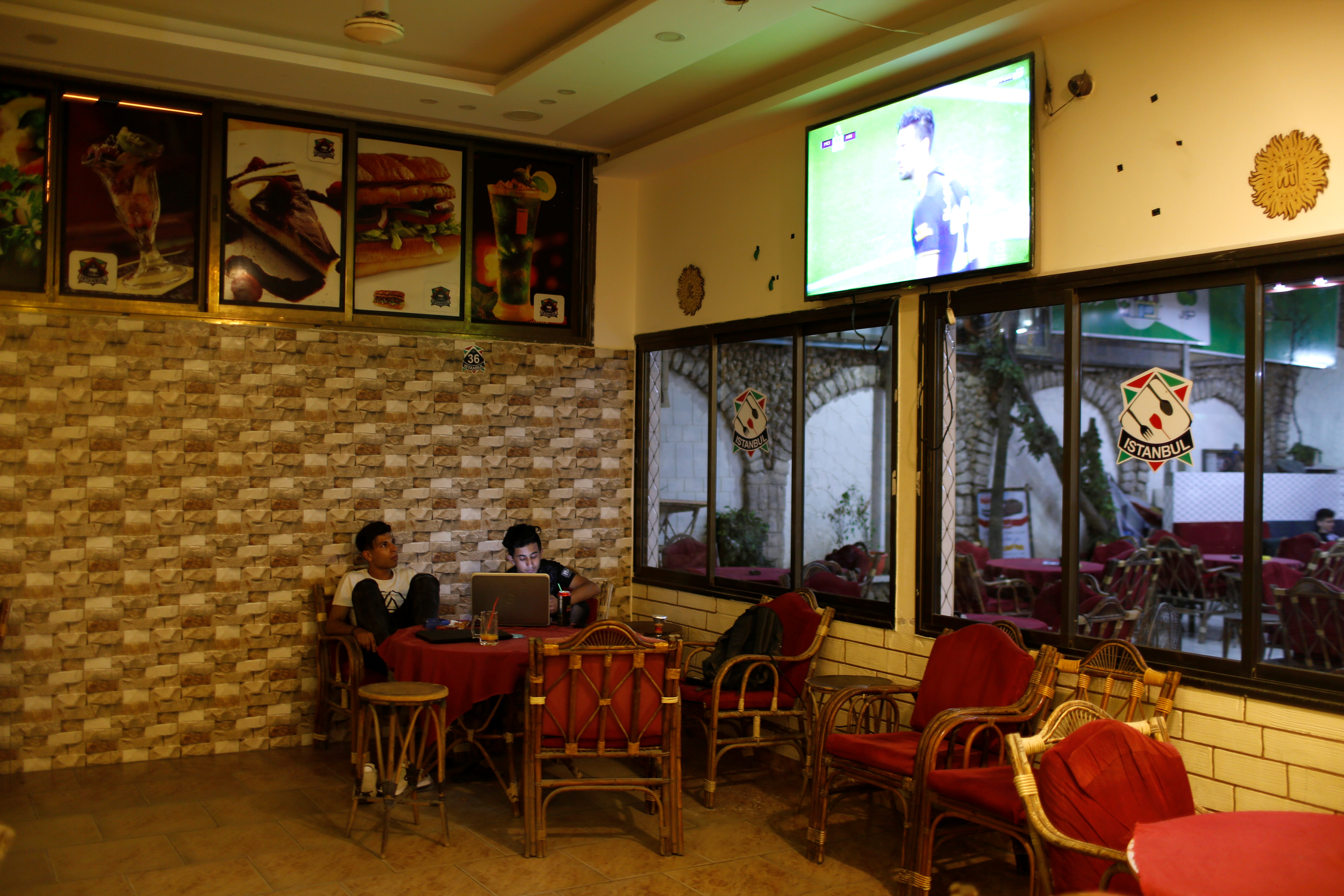 Soccer Football - Palestinians watch Premier League matches - Gaza City, Palestinian Territories - June 17, 2020 Fan watch the Premier League on tv in a cafe REUTERS/Mohammed Salem