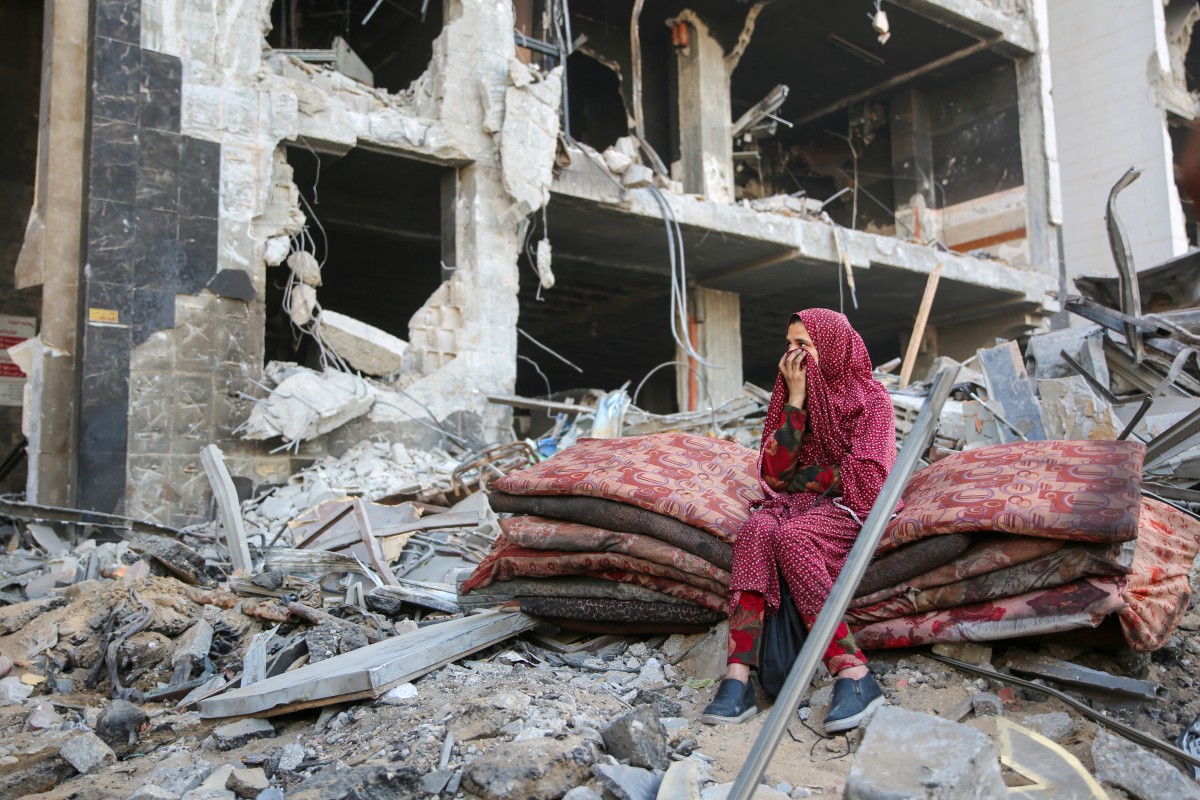 Palestinians gather around the burned and destroyed Al-Shifa Hospital