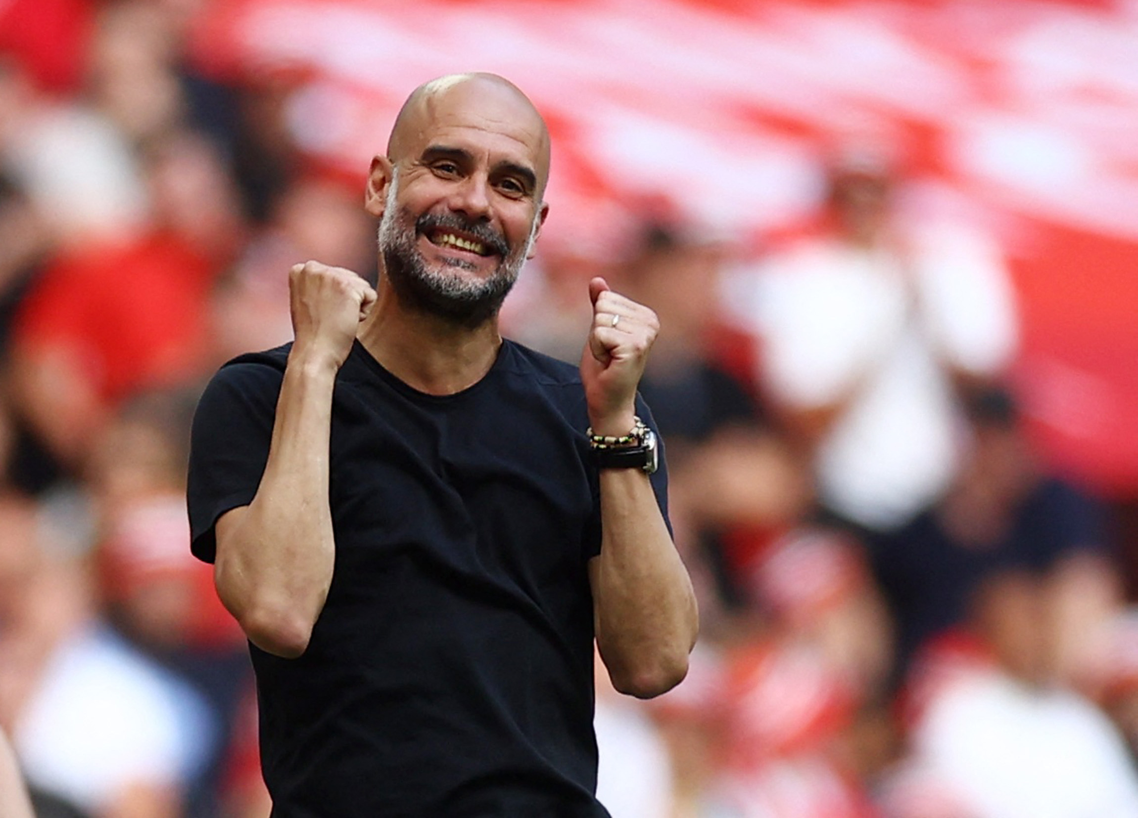 Pep Guardiola raises arms in front of his chest.