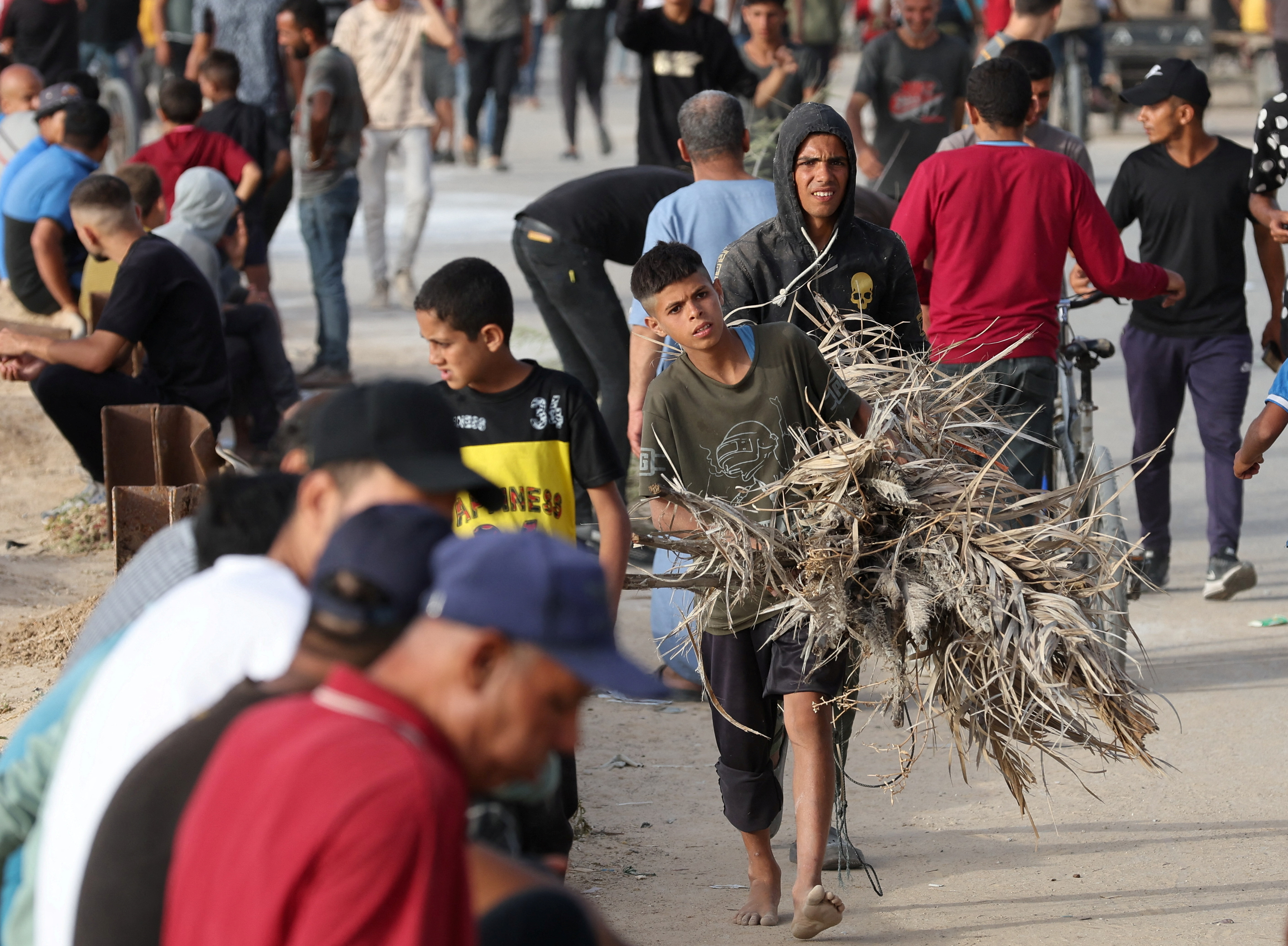 Palestinians gather in the hope of obtaining aid delivered into Gaza through a U.S.-built pier